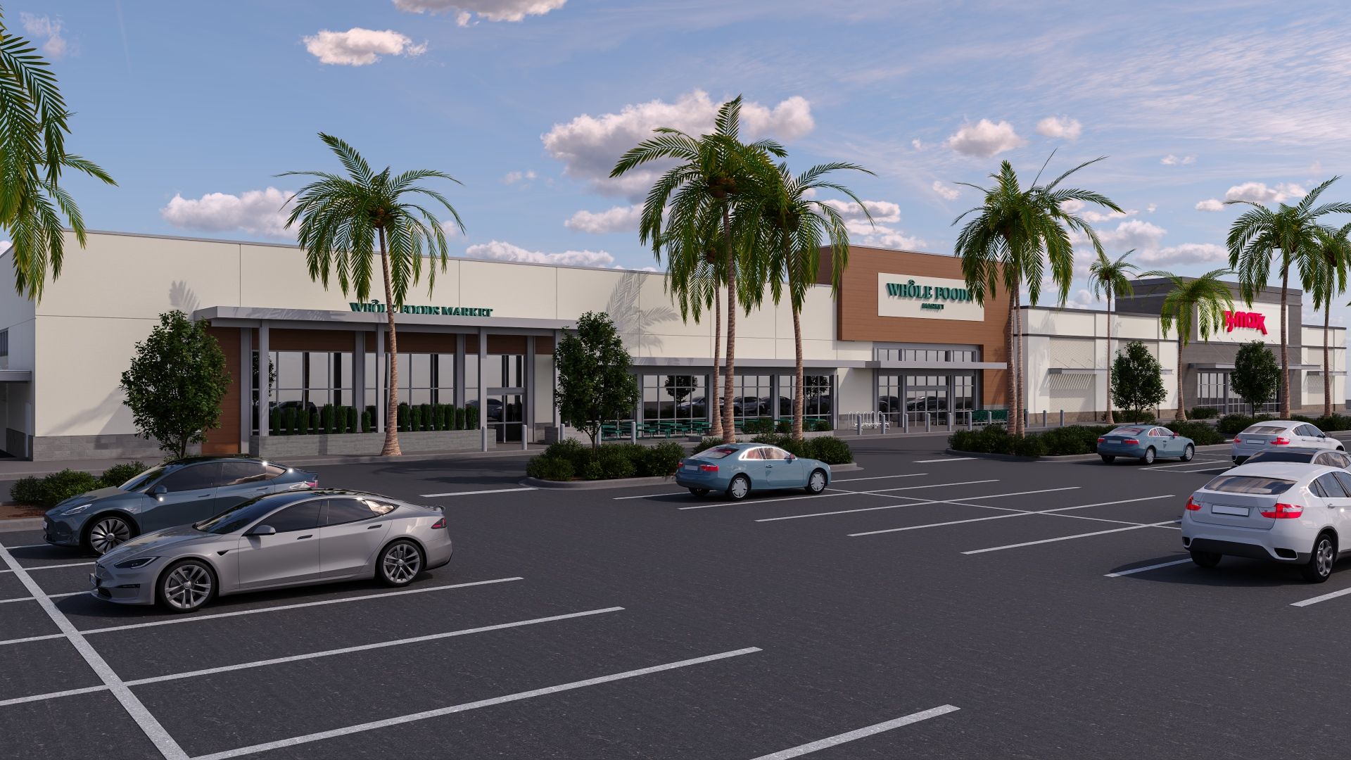 Sunny shopping plaza with palm trees along storefronts, including a green Whole Foods Market sign. Cars parked in a large lot under a bright blue sky with fluffy white clouds.