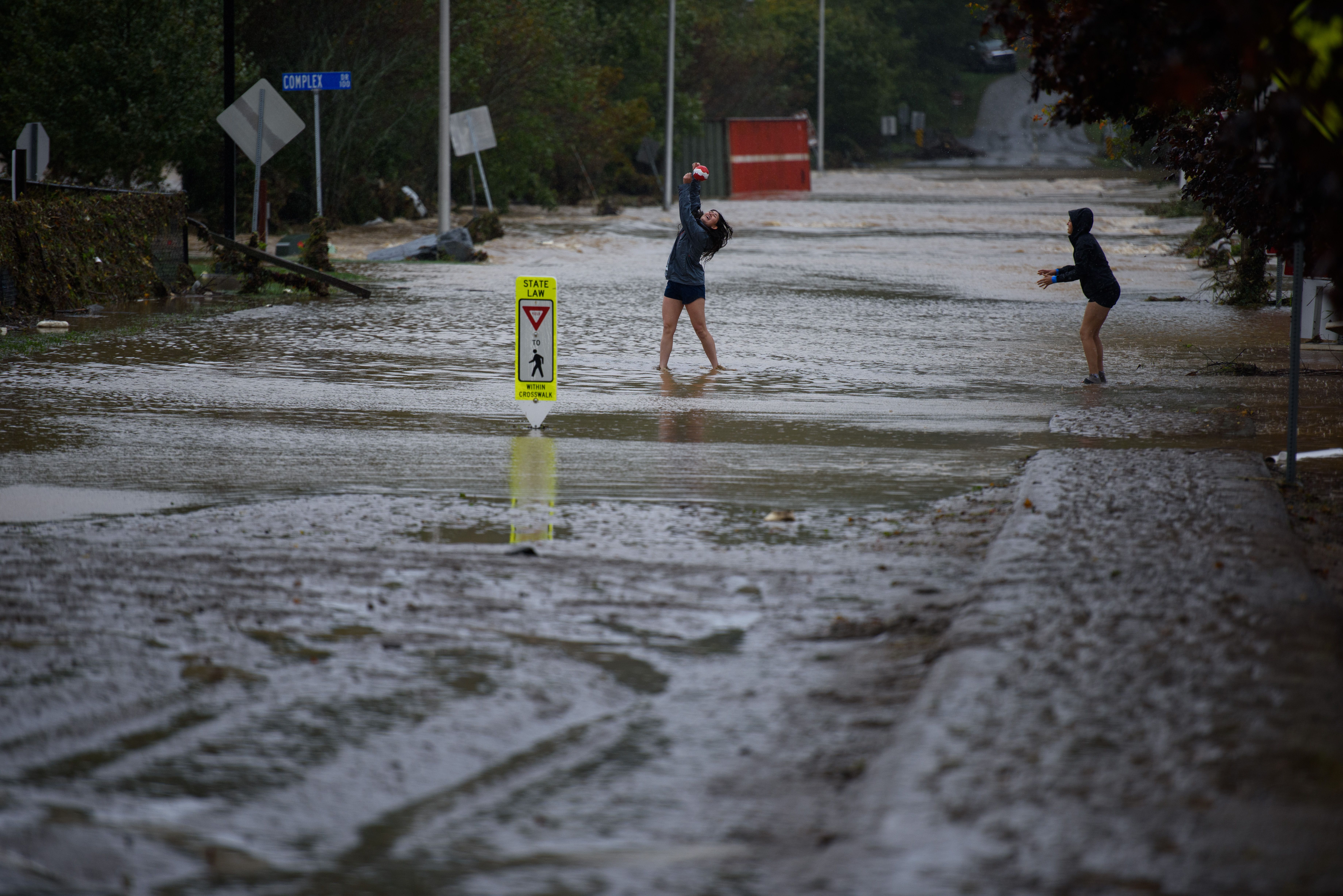 two people in a shallow but flooded street in Boone NC as Hurricane Helene hit