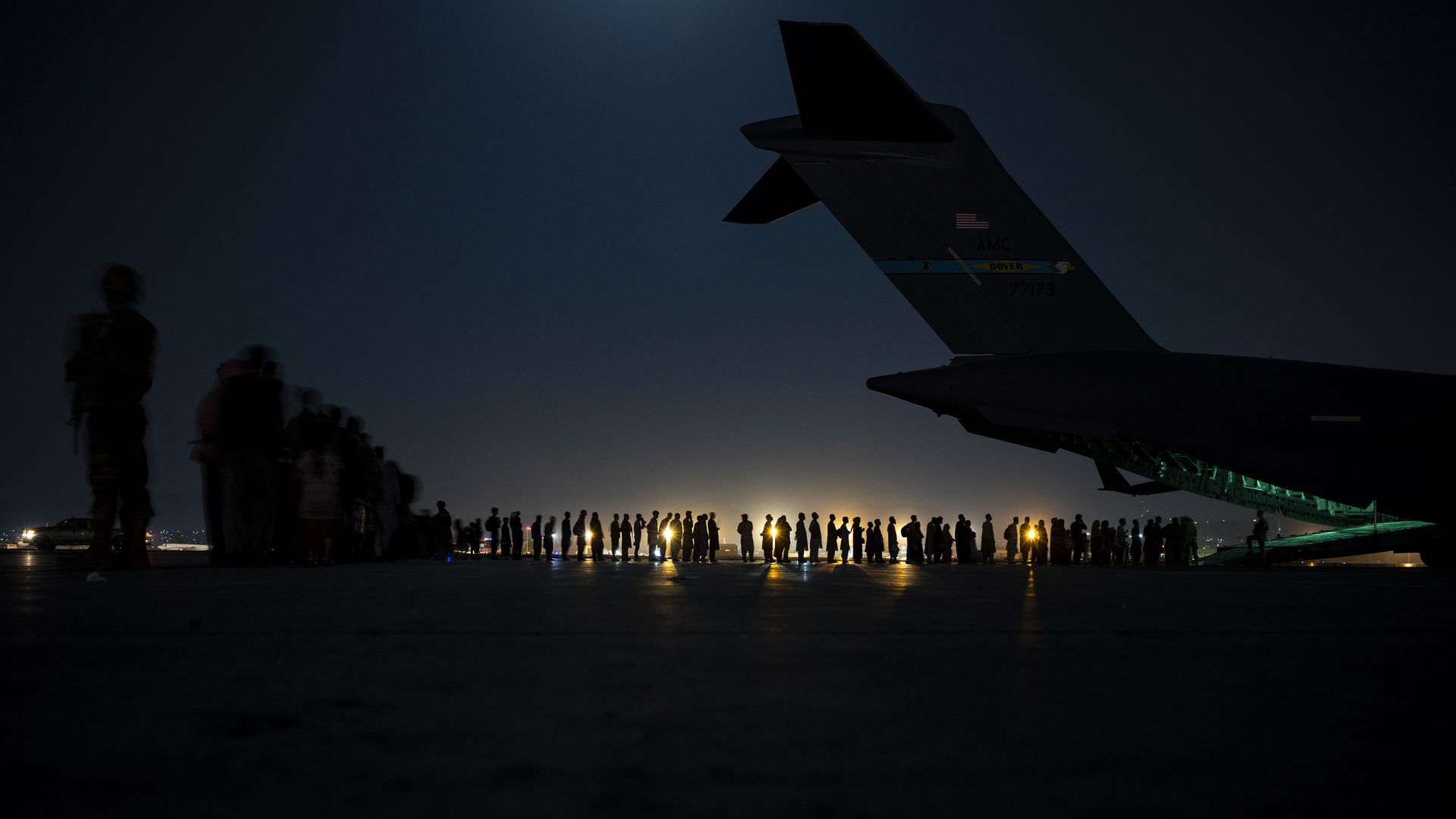 Evacuees are seen lining up on Saturday before boarding a U.S. Air Force C-17 transport at Kabul's airport.