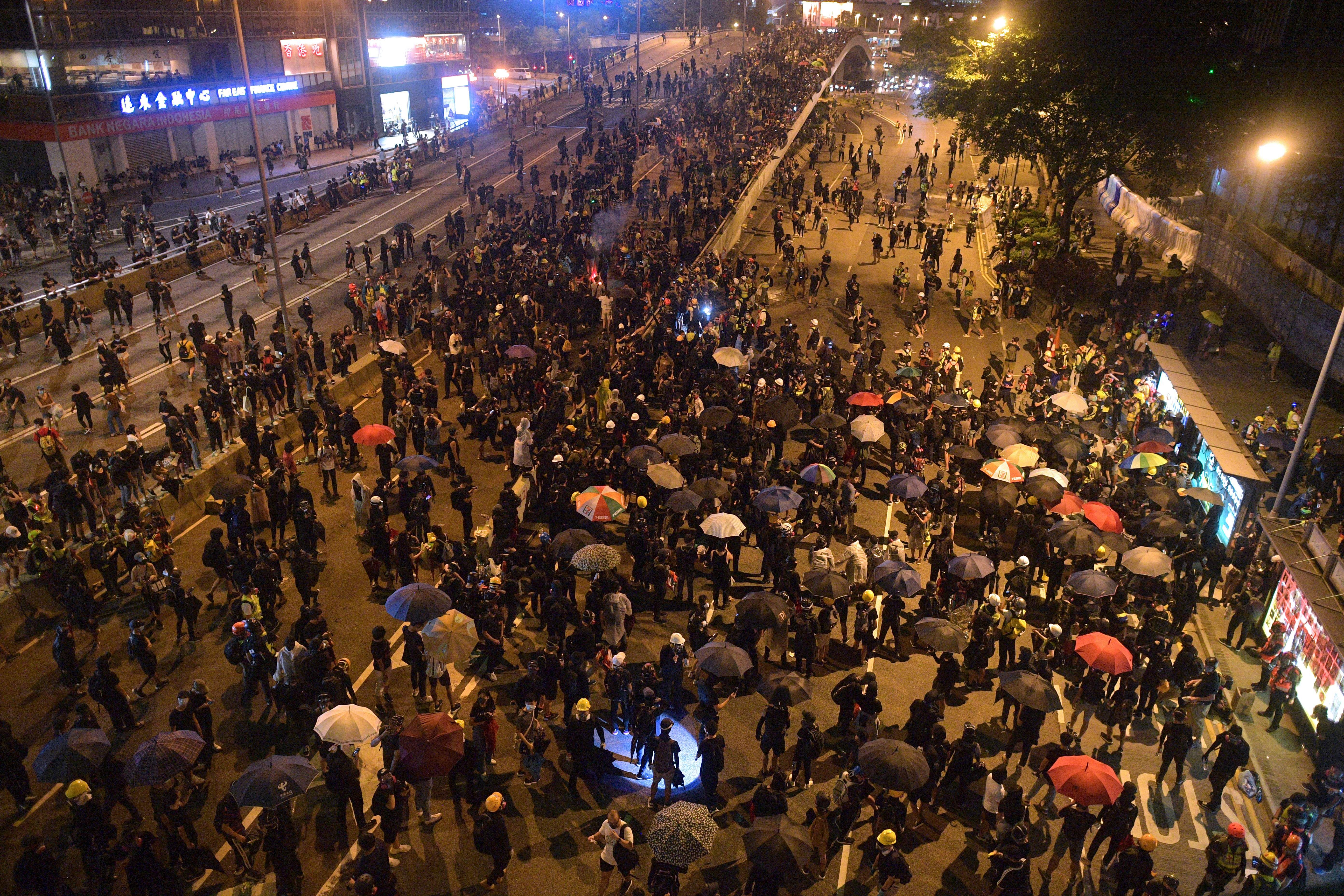 Protesters occupy a main road outside the central government offices (R) in the Admiralty area