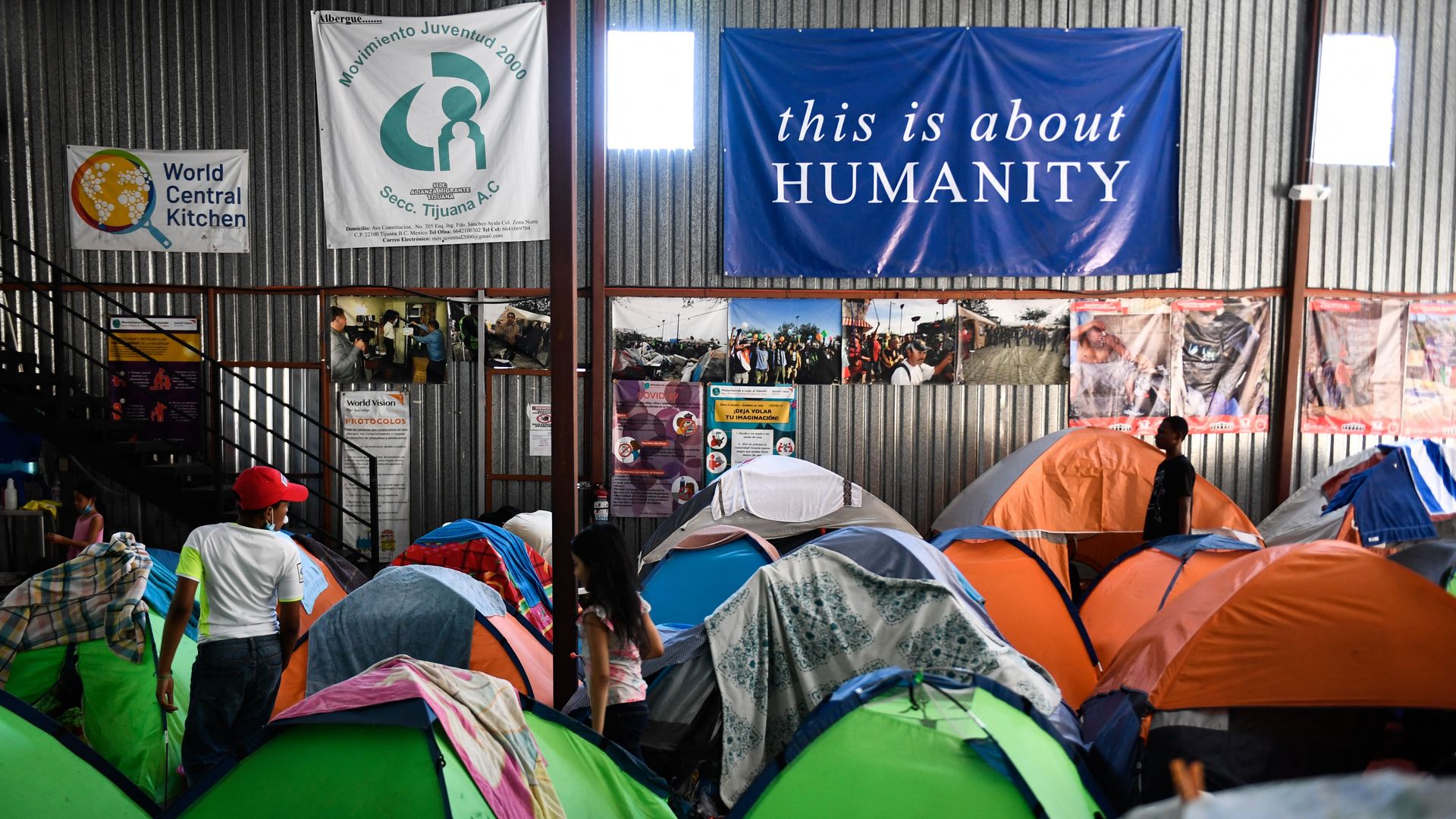 Families with children live in tents the Movimiento Juventud 2000 shelter with refugee migrants