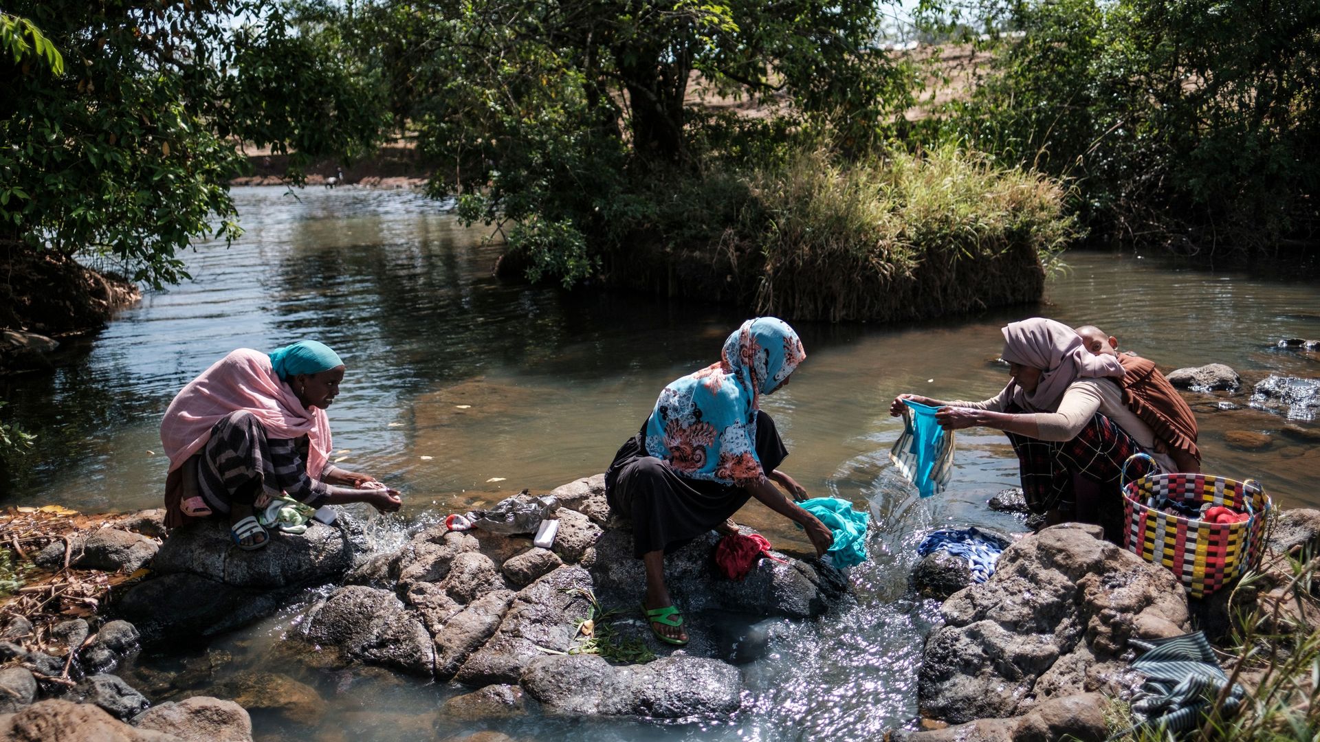 Women washing clothes by a river