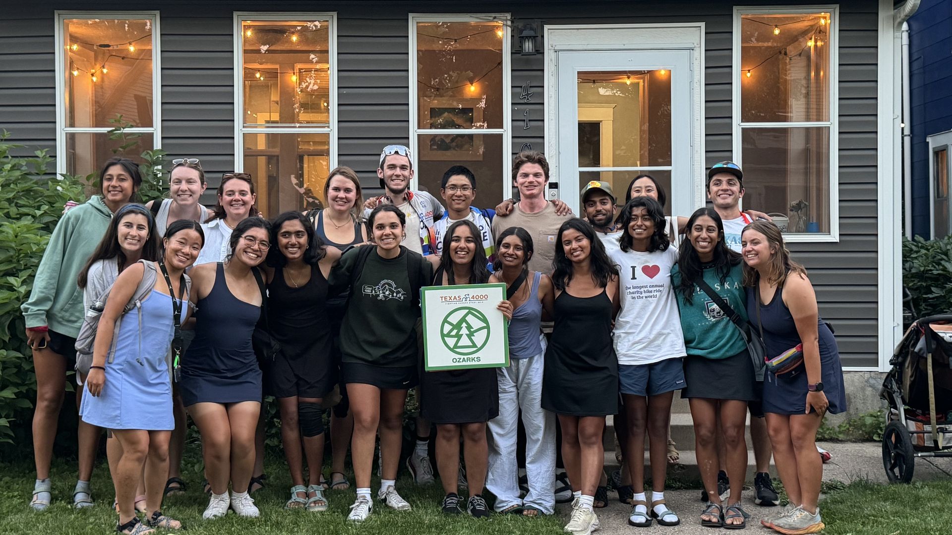 A photo of a group of people standing in front of a house.