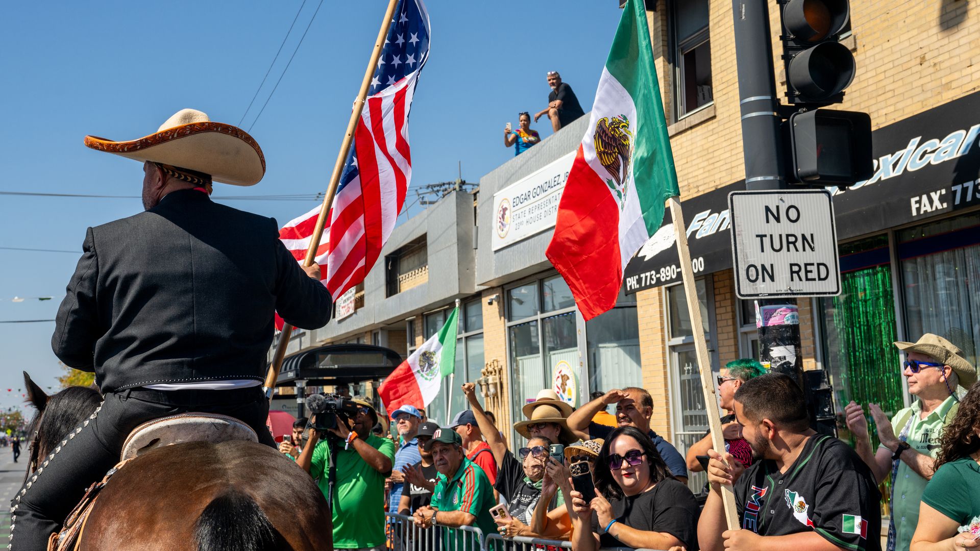 A photo shows a man on a horse holding an American flag while marching in a parade.