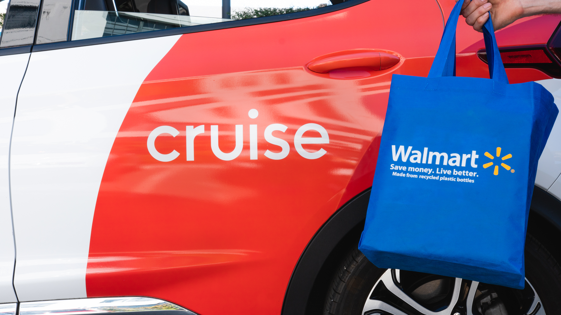 Image of a Walmart shopping bag and a Cruise self-driving test vehicle