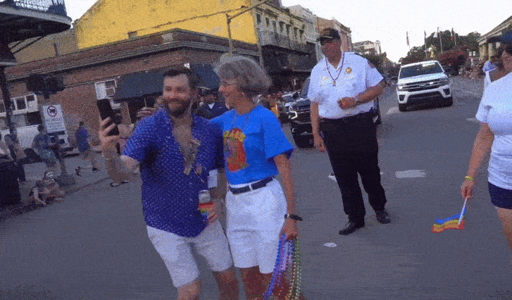 Gif shows NOPD Anne Kirkpatrick in a high-rat shirt taking a selfie with a man at the New Orleans Pride parade.