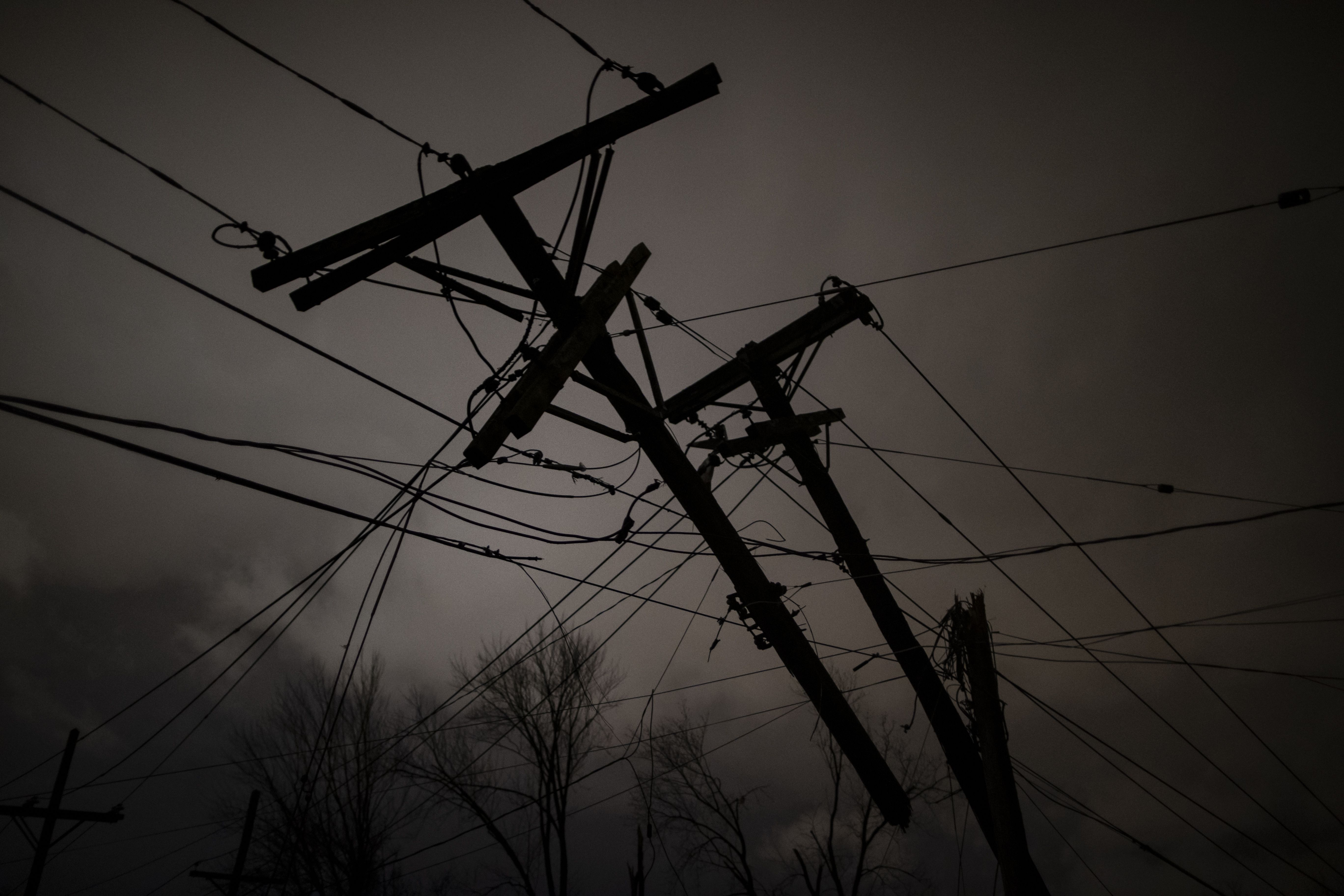 Damaged utility poles and lines hang above a street in Nashville on March 3