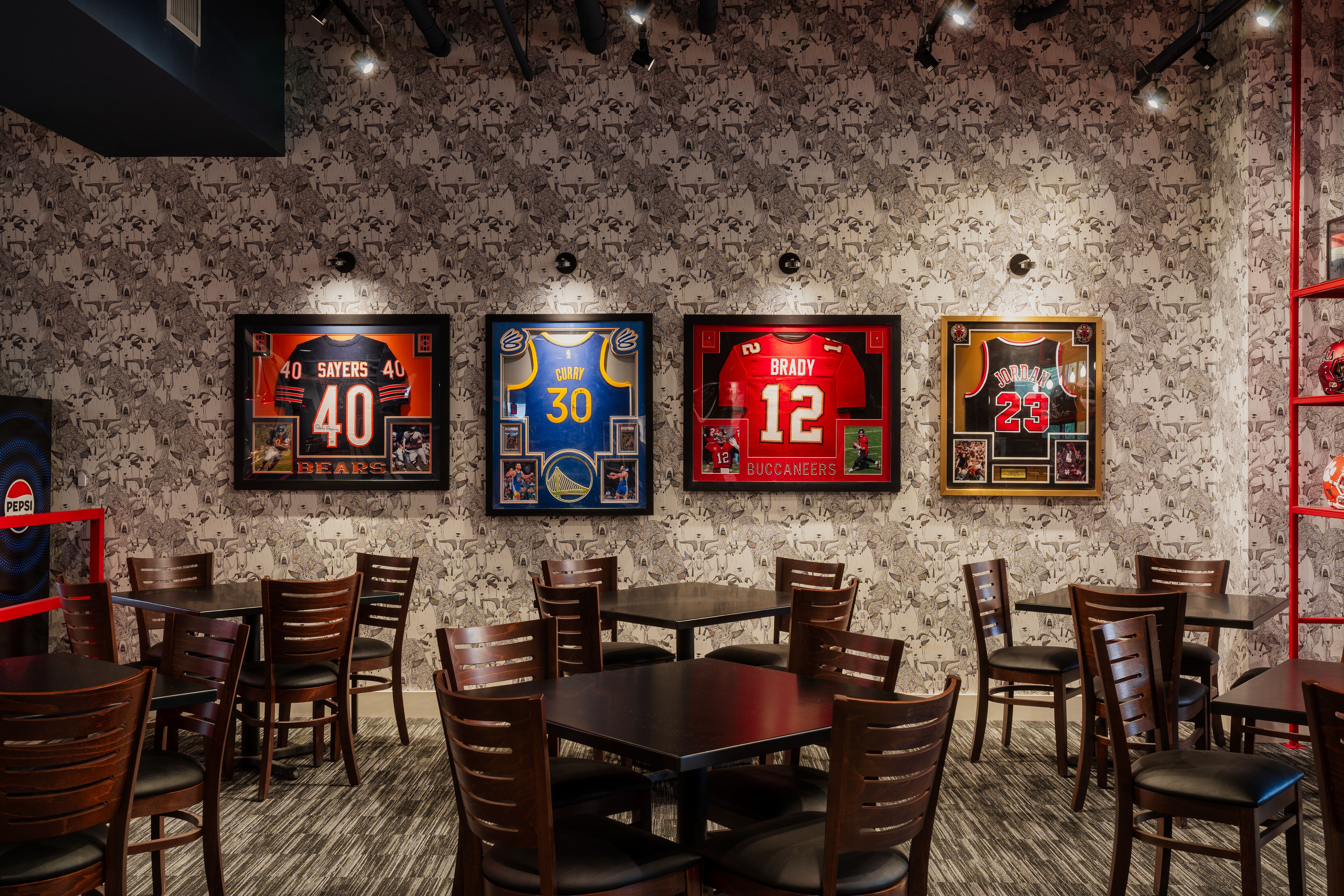 table seating at a restaurant with framed sports jerseys on the wall