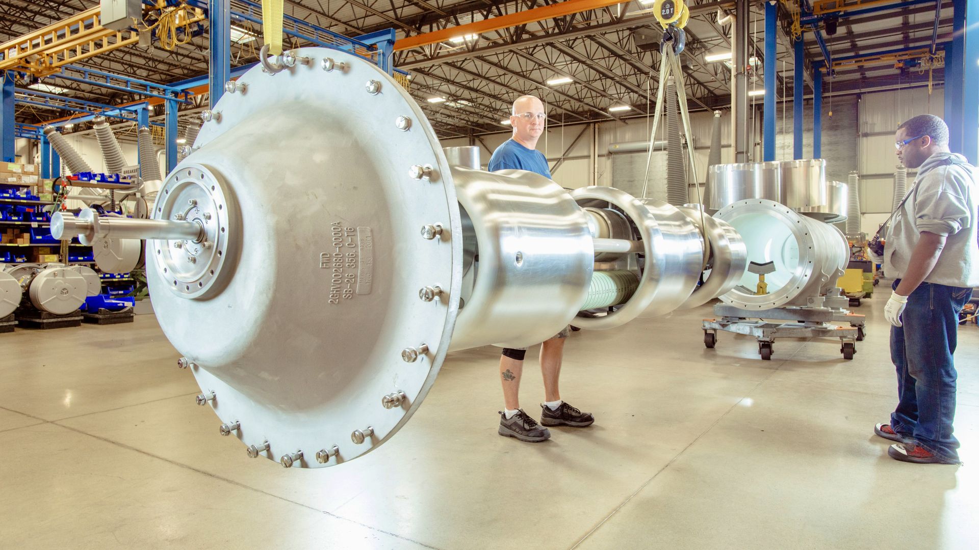 A man holds a large piece of equipment.