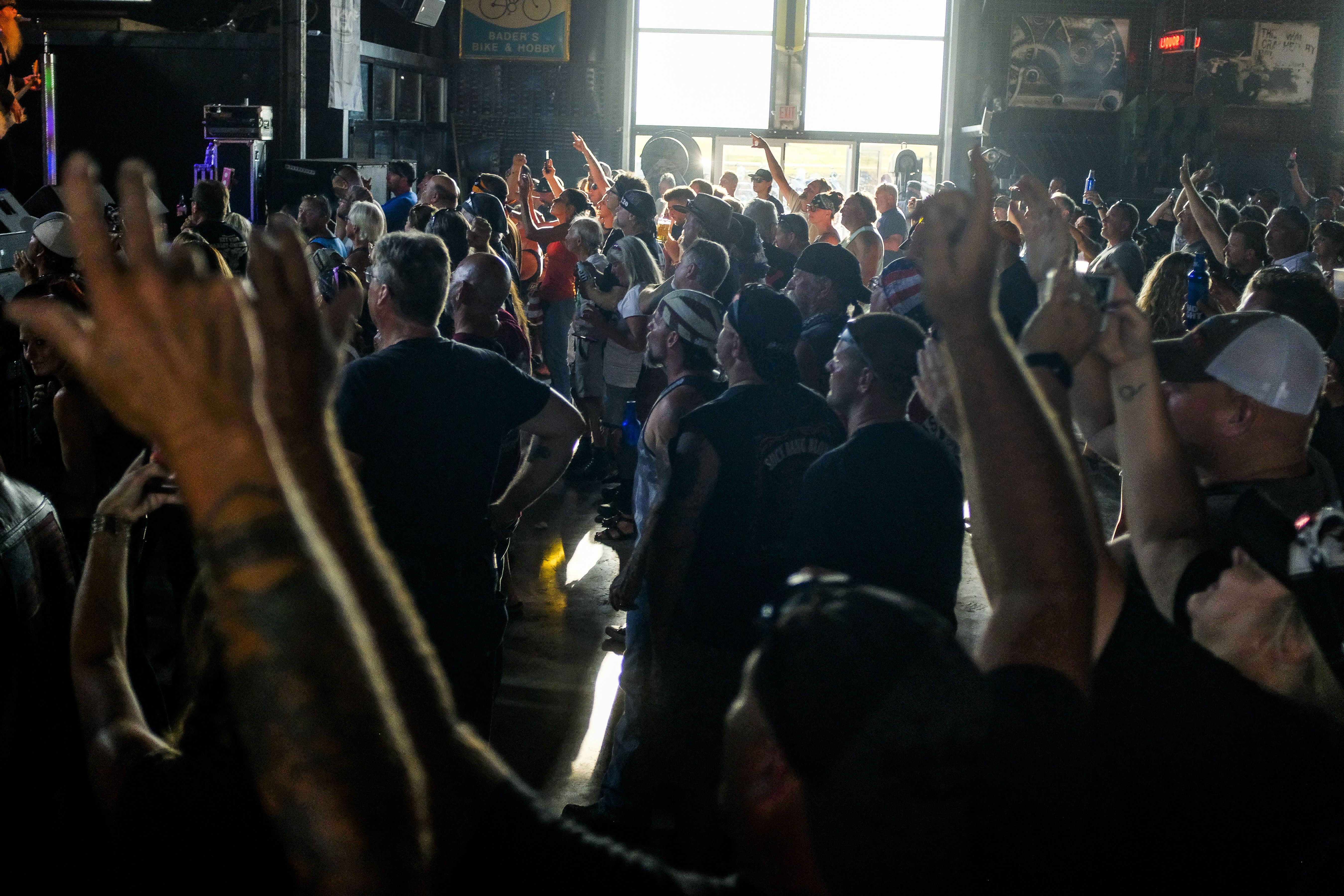 People cheer during a concert in a saloon on August 7.