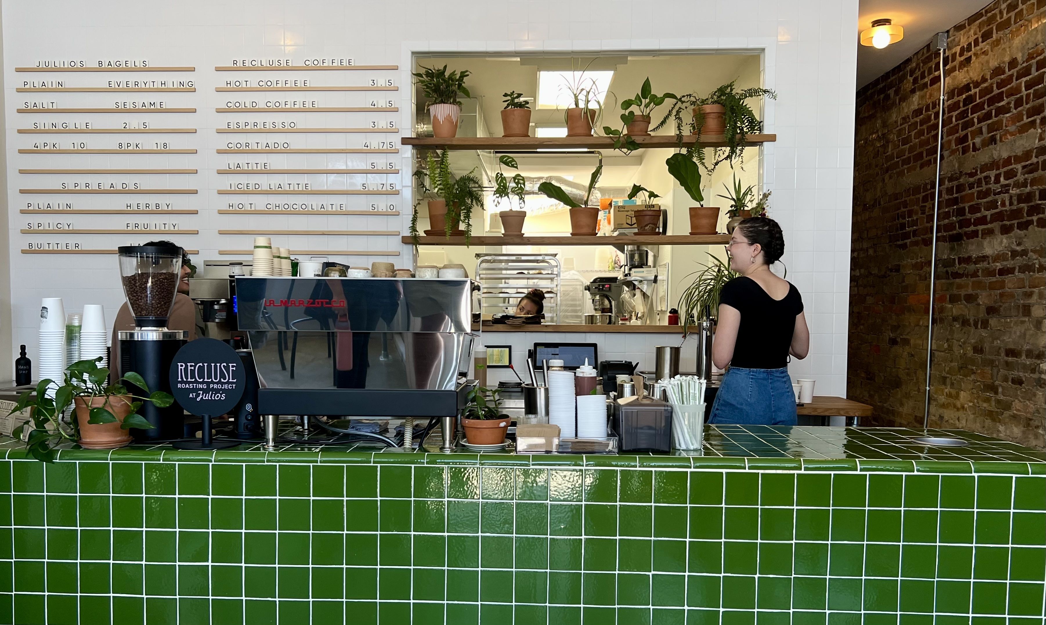inside of a shop with green tiles and people 