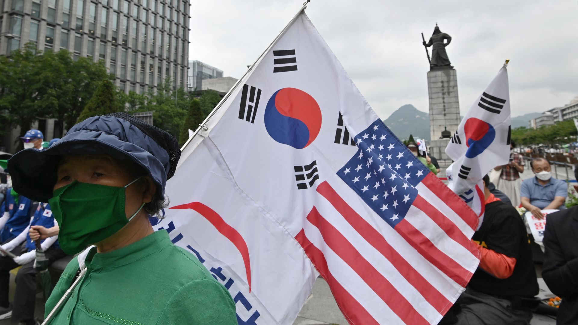 A South Korean woman holds flags of South Korea and the US during a rally commemorating the 70th anniversary of the beginning of the Korean War in Seoul on June 25
