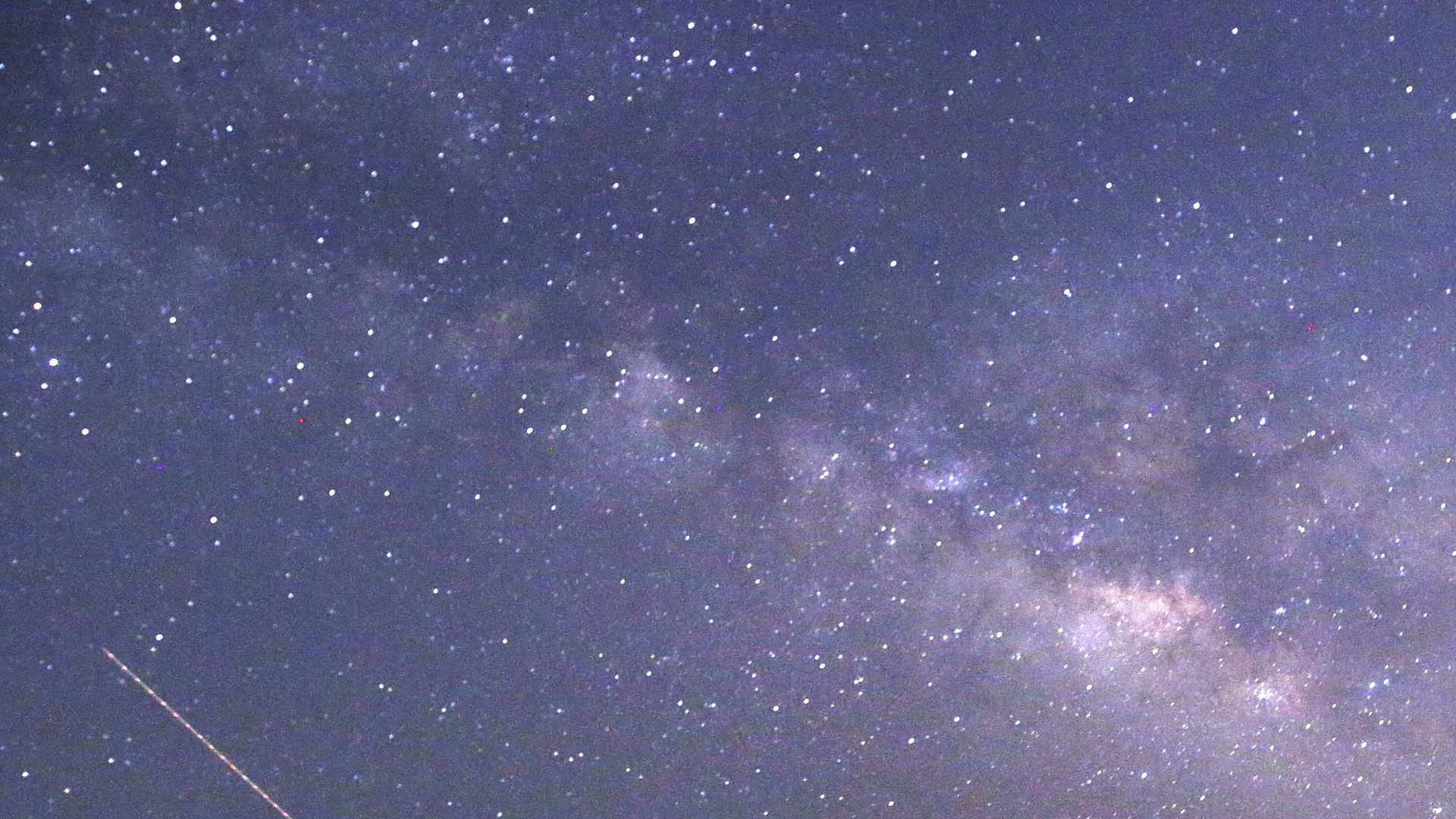 Meteors, stars and the Milky Way in an indigo sky.