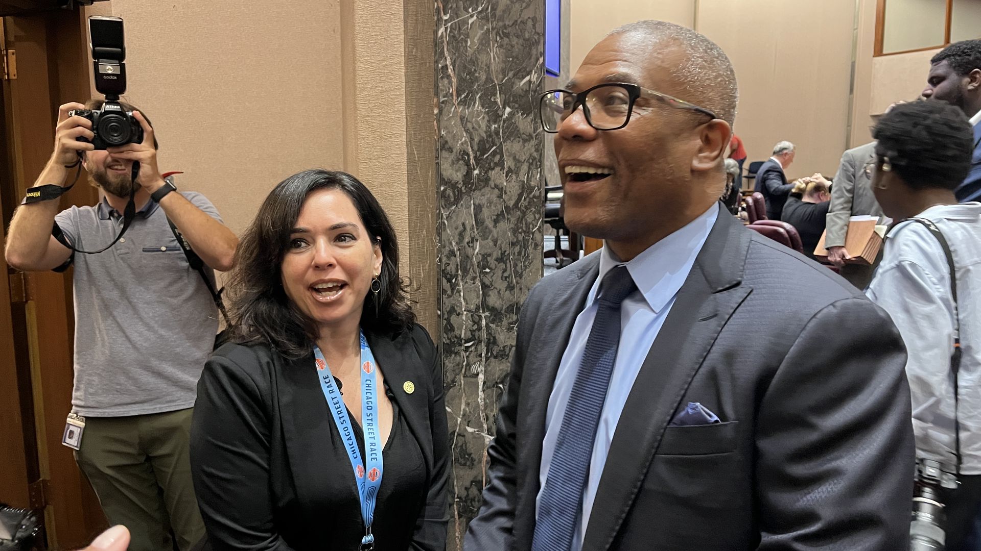 Photo of a man smiling posing for cameras. 