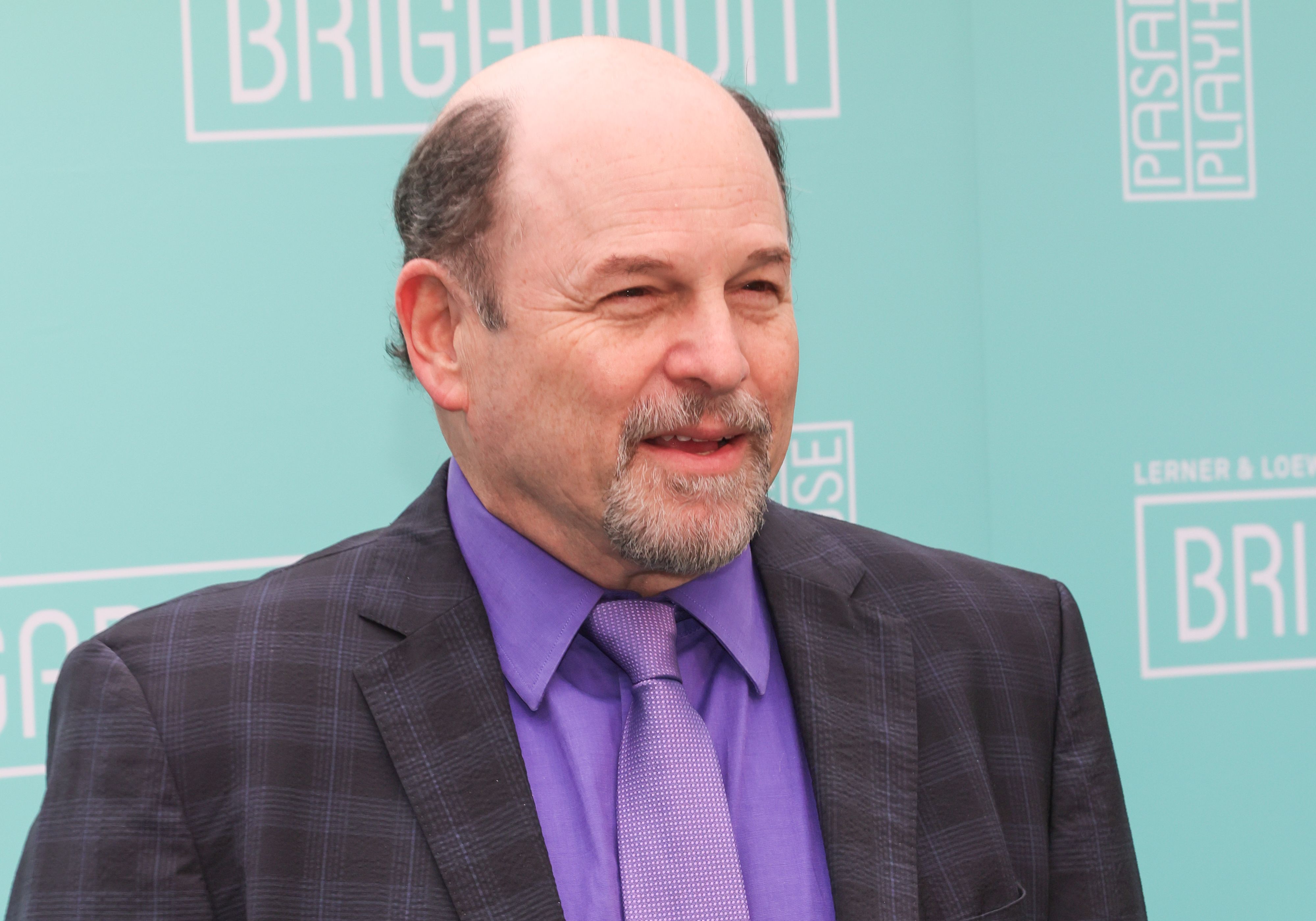 Photo of a man posing for photos at a opening red carpet.