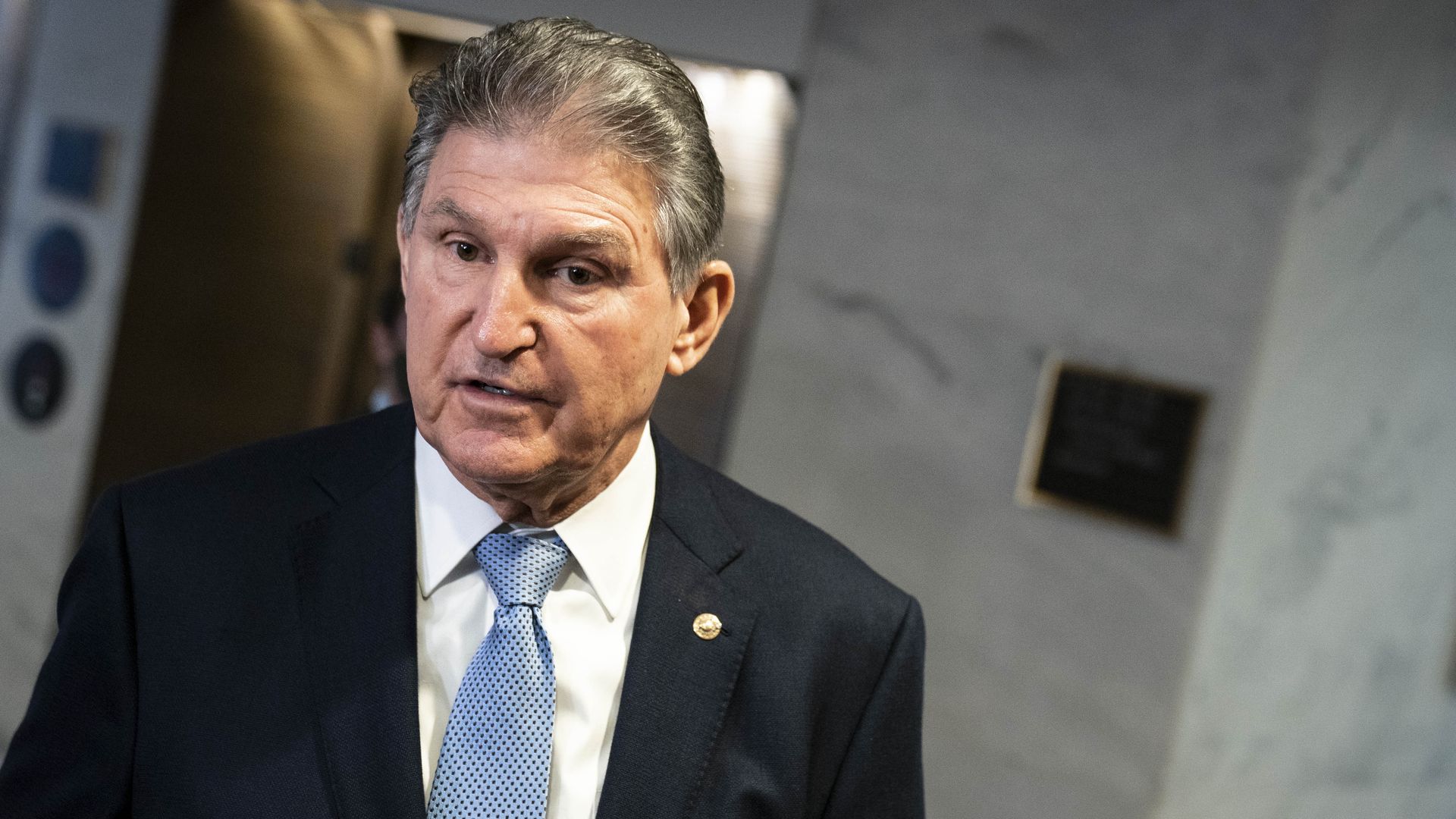 Sen. Joe Manchin (D-W.Va.) stands in front of an elevator at the Capitol.