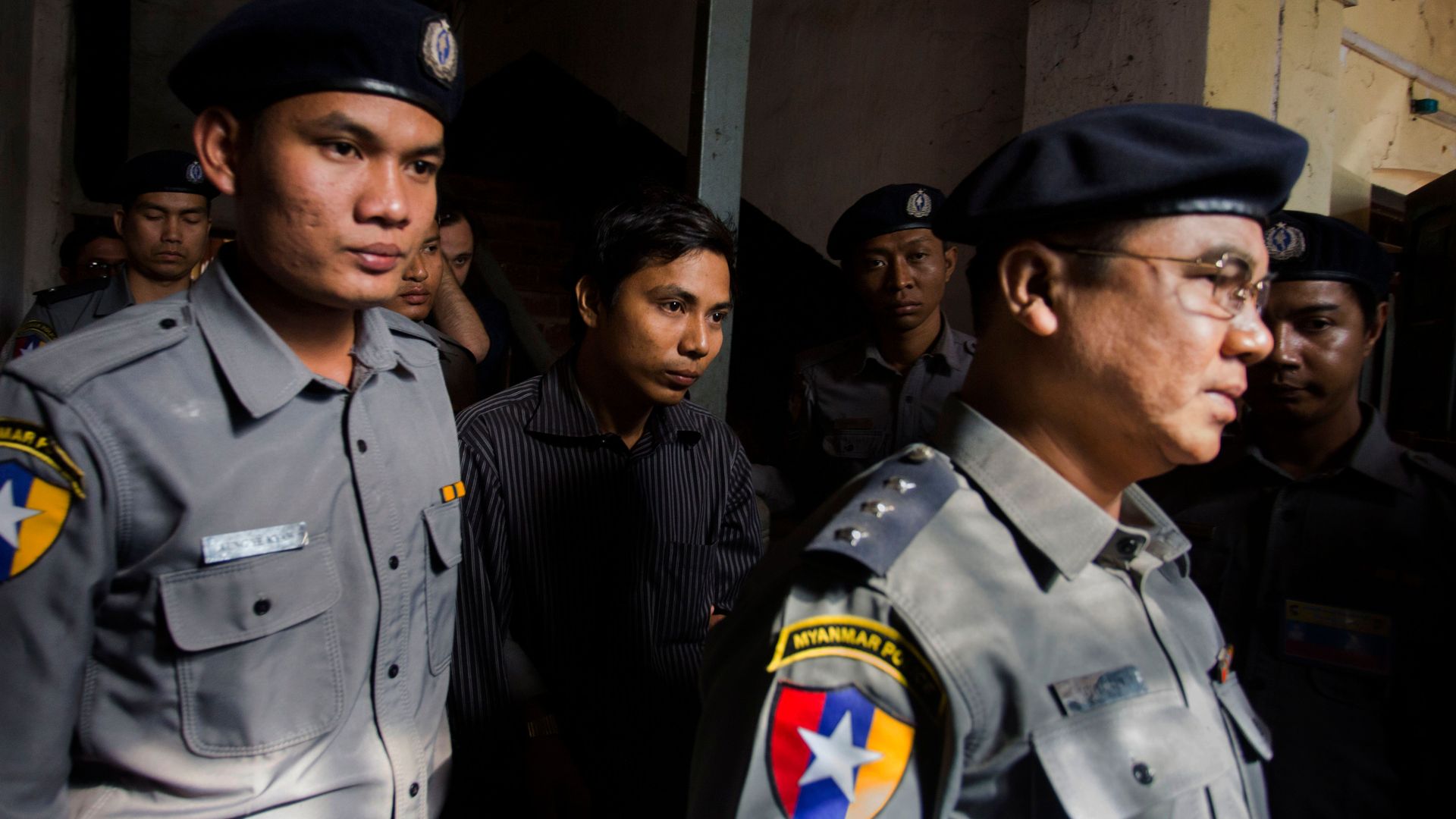 Reuters journalist Kyaw Soe Oo is escorted by Myanmar police outside the northern district court in Yangon