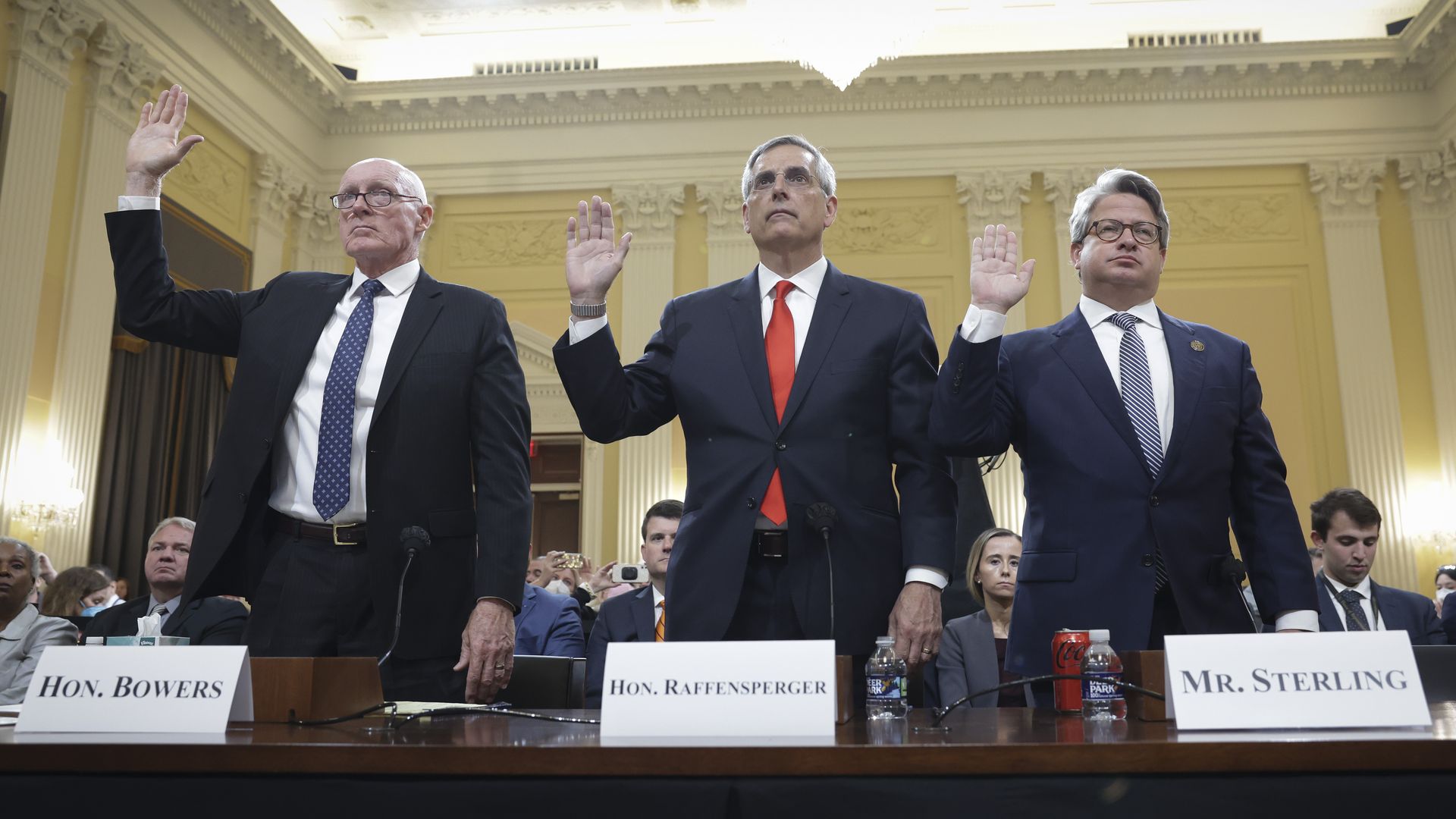 Three men holding their right hands up swearing to tell the truth