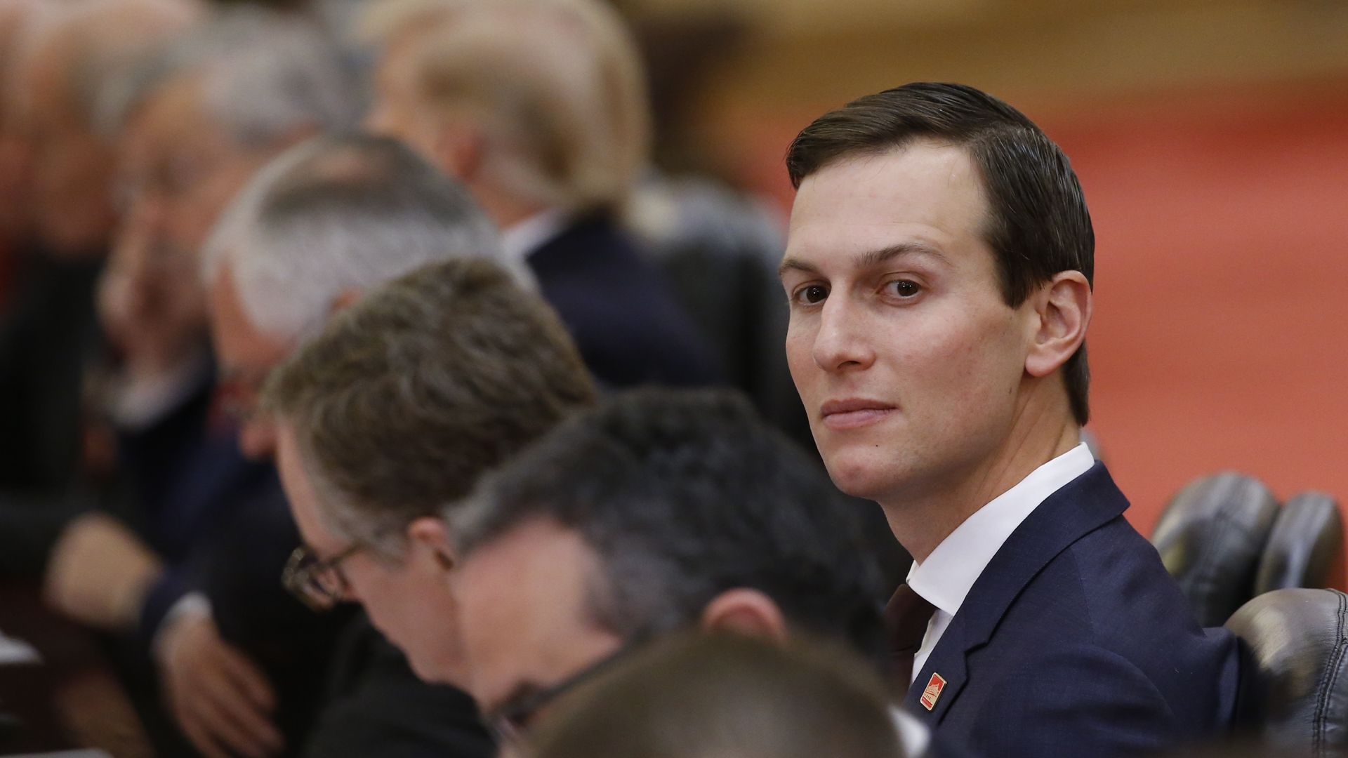 Jared Kushner picks his head up from a table