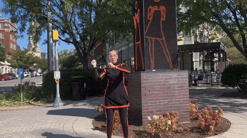 A woman dancing next to a video of a woman dancing