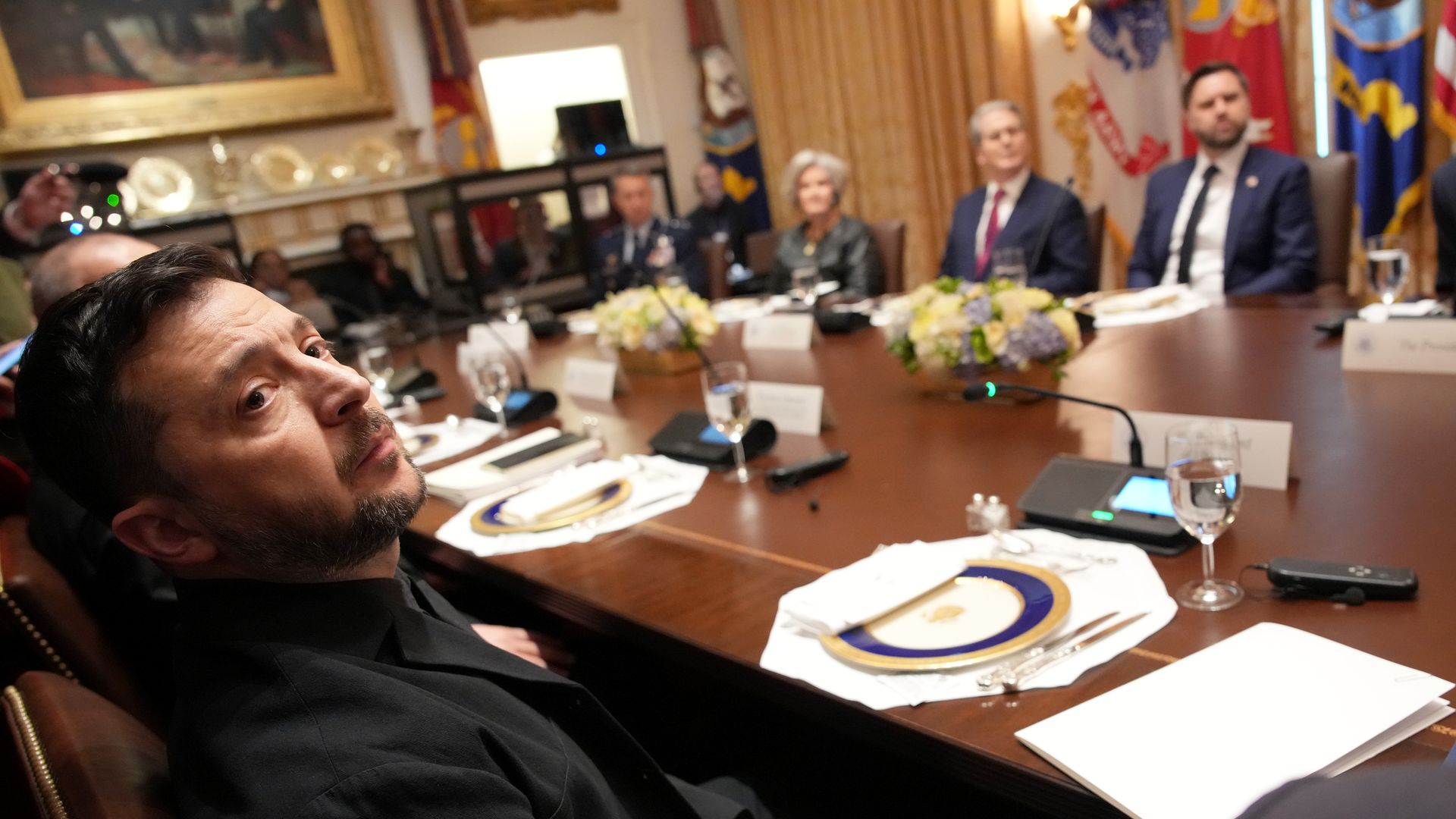 Man at table in foreground with men and women across 