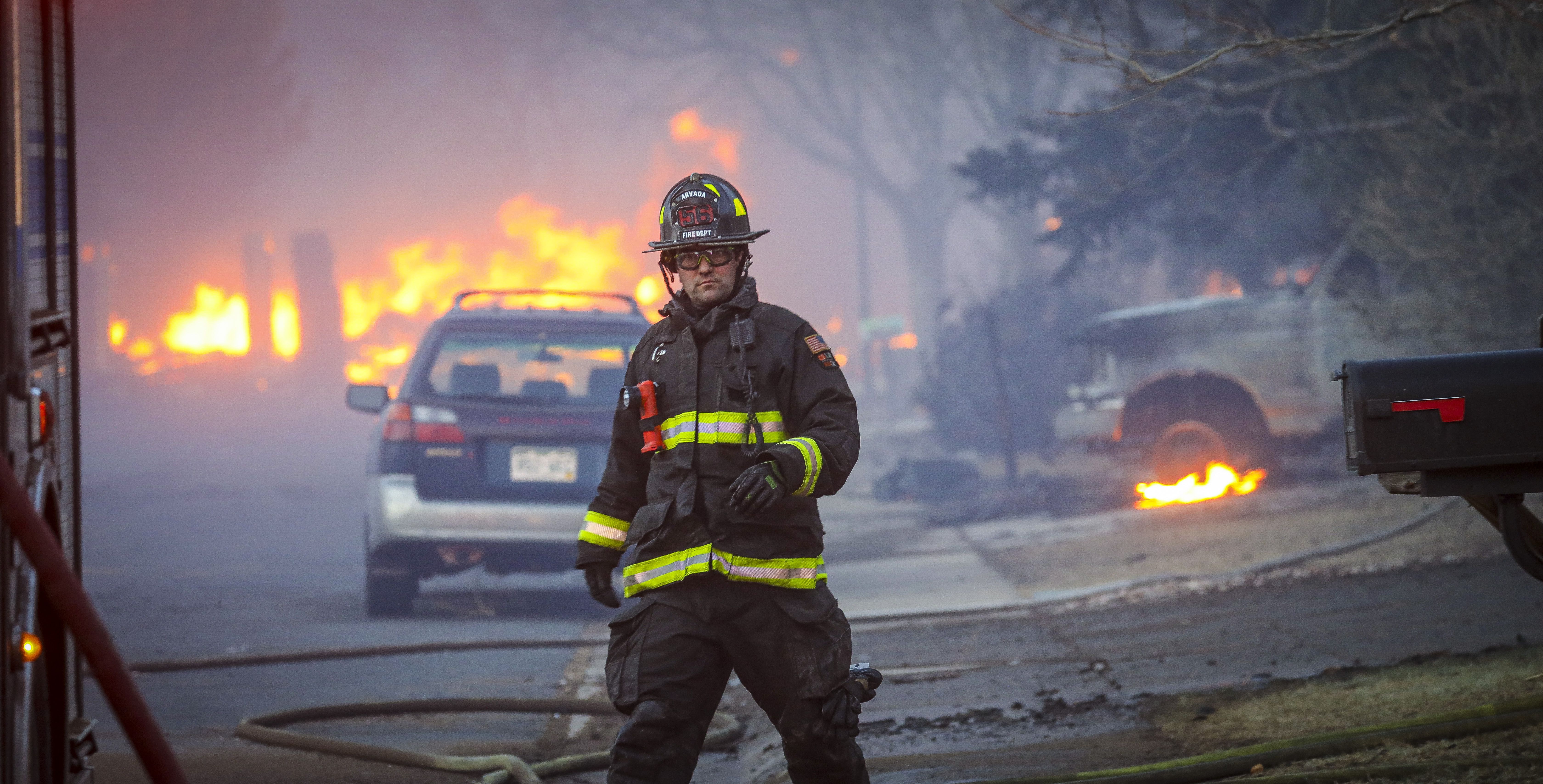 An Arvada firefighter walks back to the firetruck as a fast moving wildfire swept through the area.