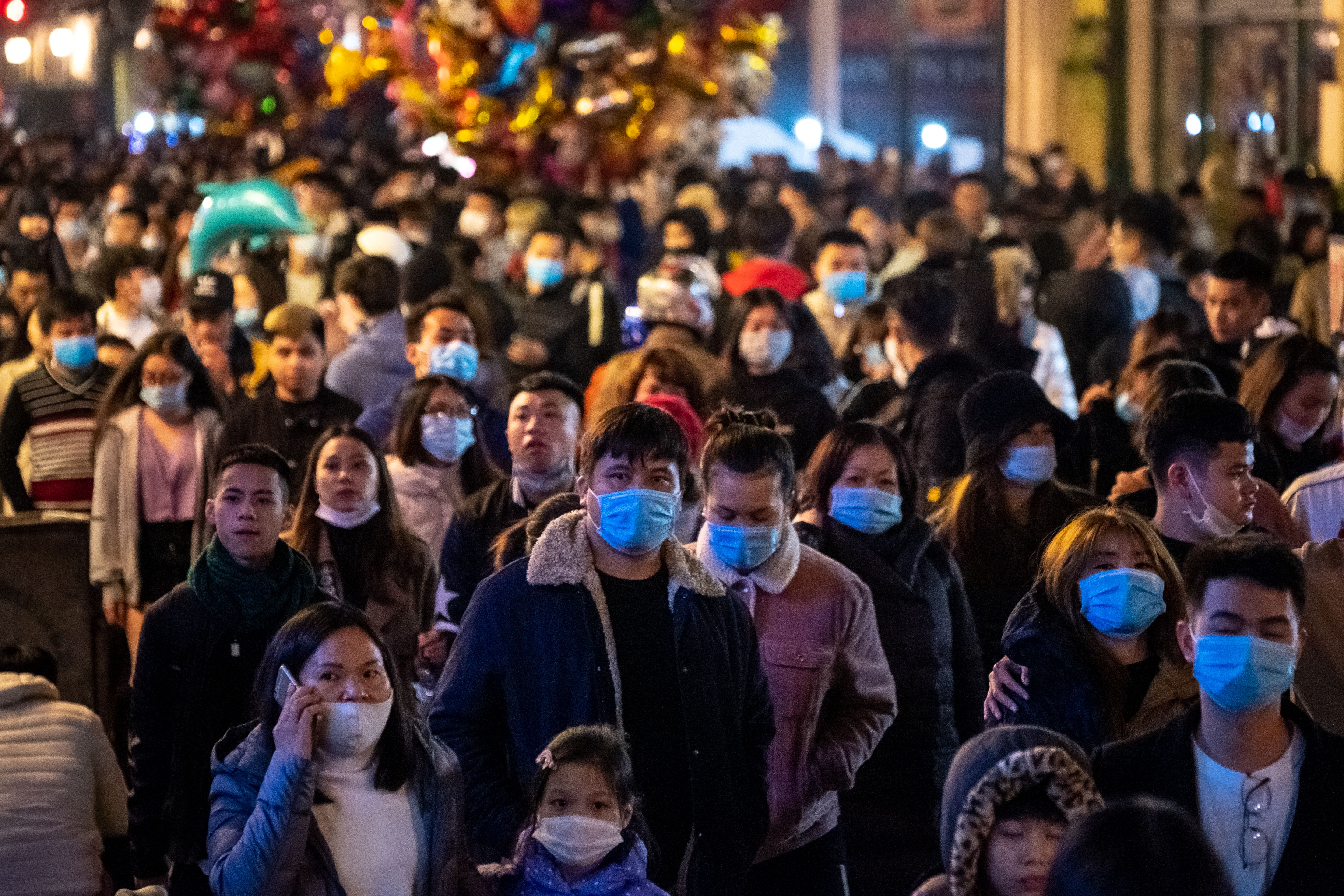 People wear protective face masks while attending a public New Year's Eve countdown party in Hanoi, Vietnam. 