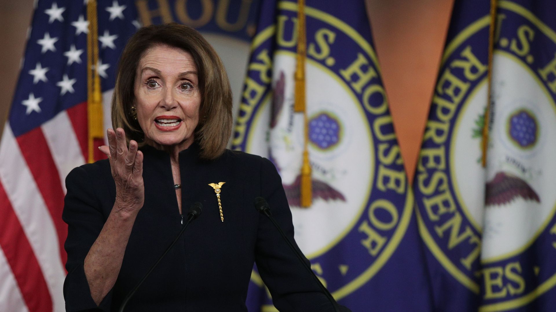 House Speaker Nancy Pelosi gestures with one hand.