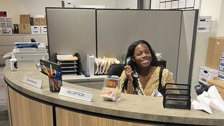 Paige sits at the recreated set of the Office. 