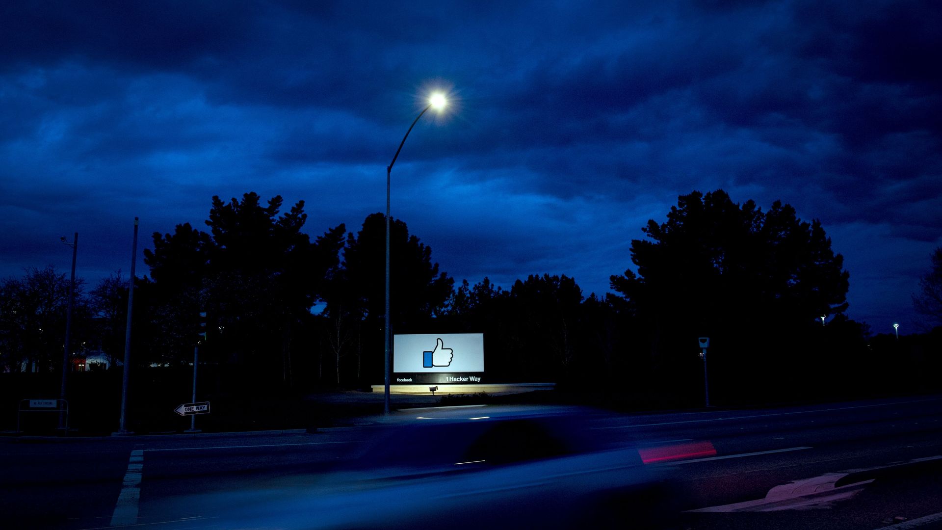 A sign in front of Facebook's headquarters at night