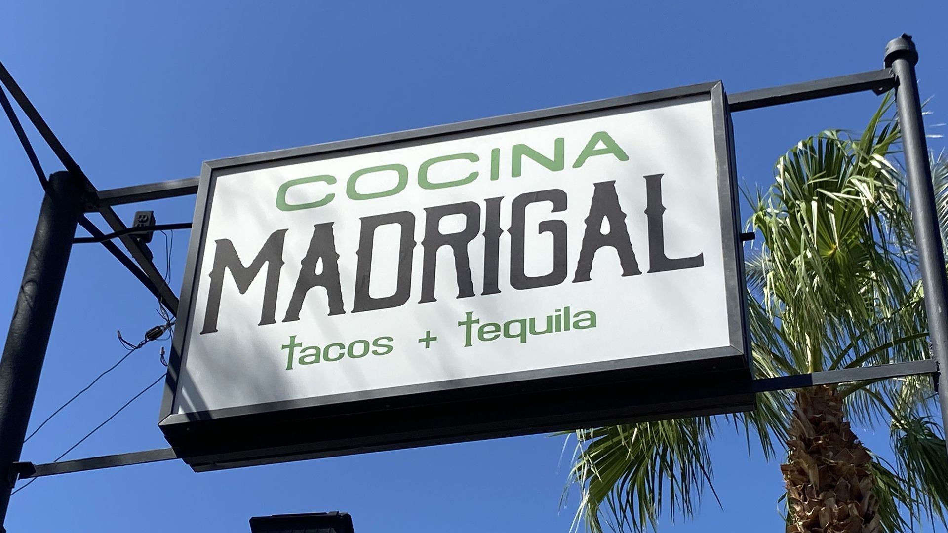 A sign that says, "COCINA MADRIGAL tacos + tequila."