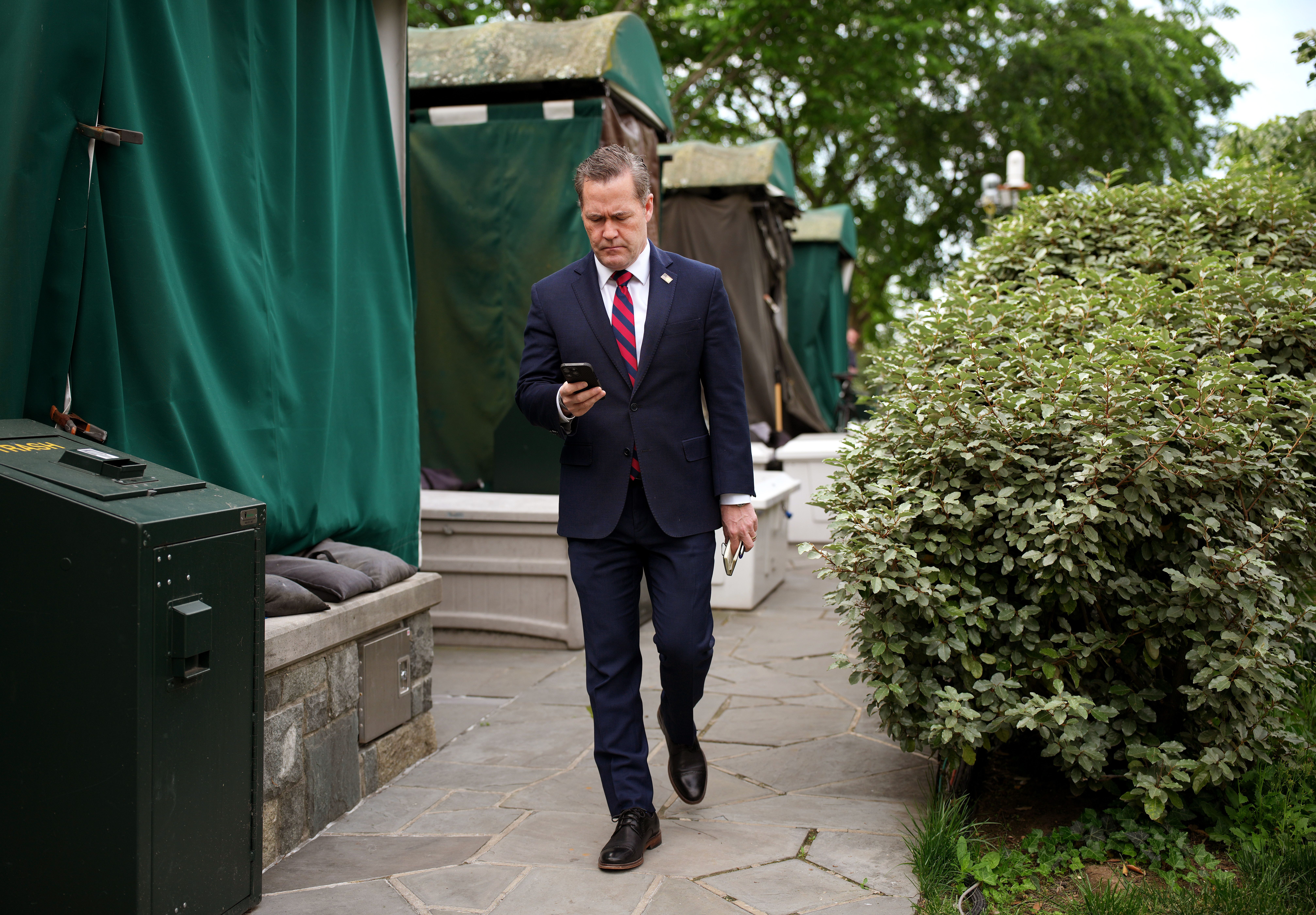 National security adviser Mike Waltz looks at his phone ahead of a TV interview at the White House on Thursday. Photo: Andrew Harnik/Getty Images