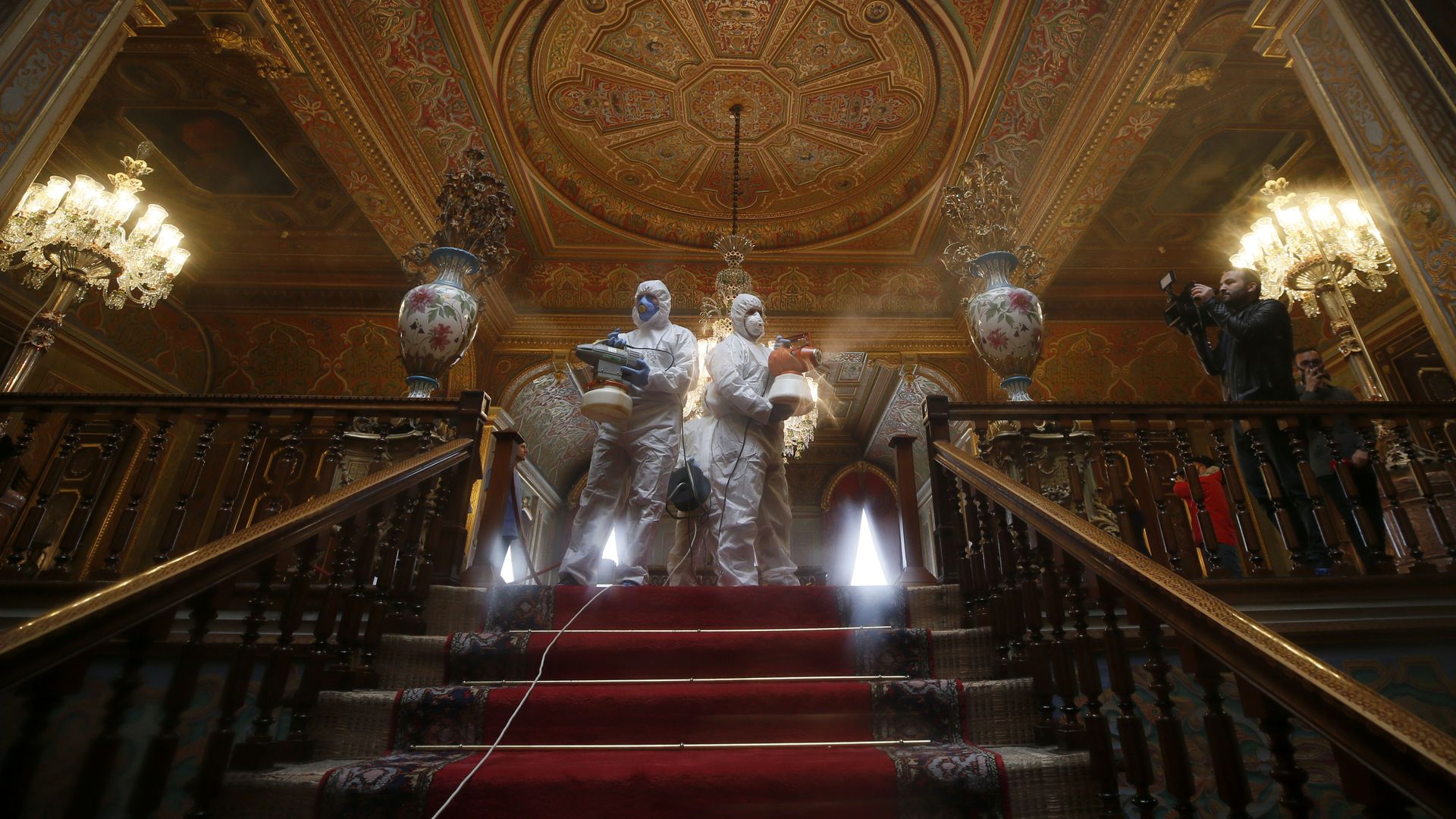Men in suits disinfecting stairs