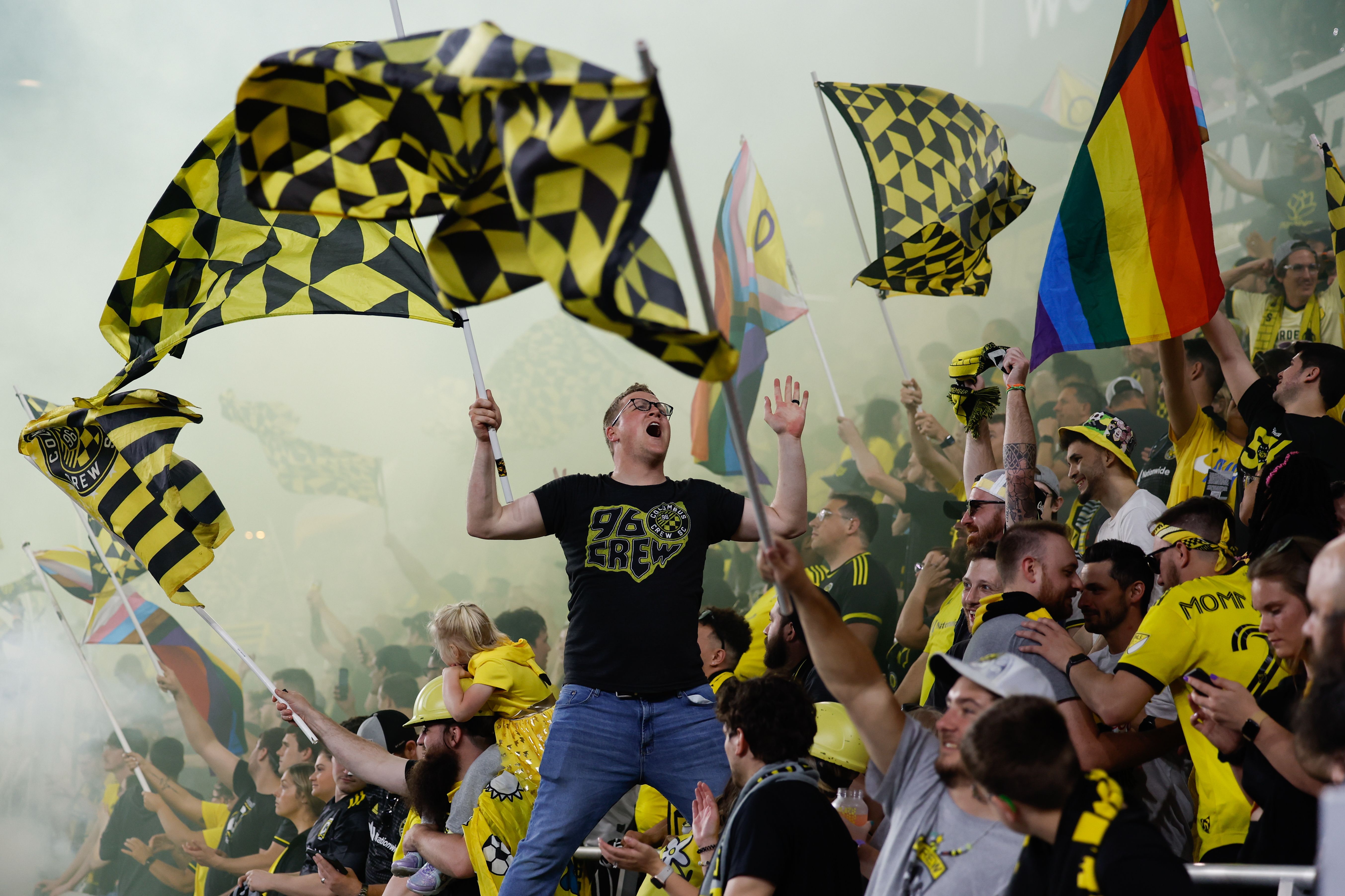 Columbus Crew fans celebrate a goal with flags and cheers. 