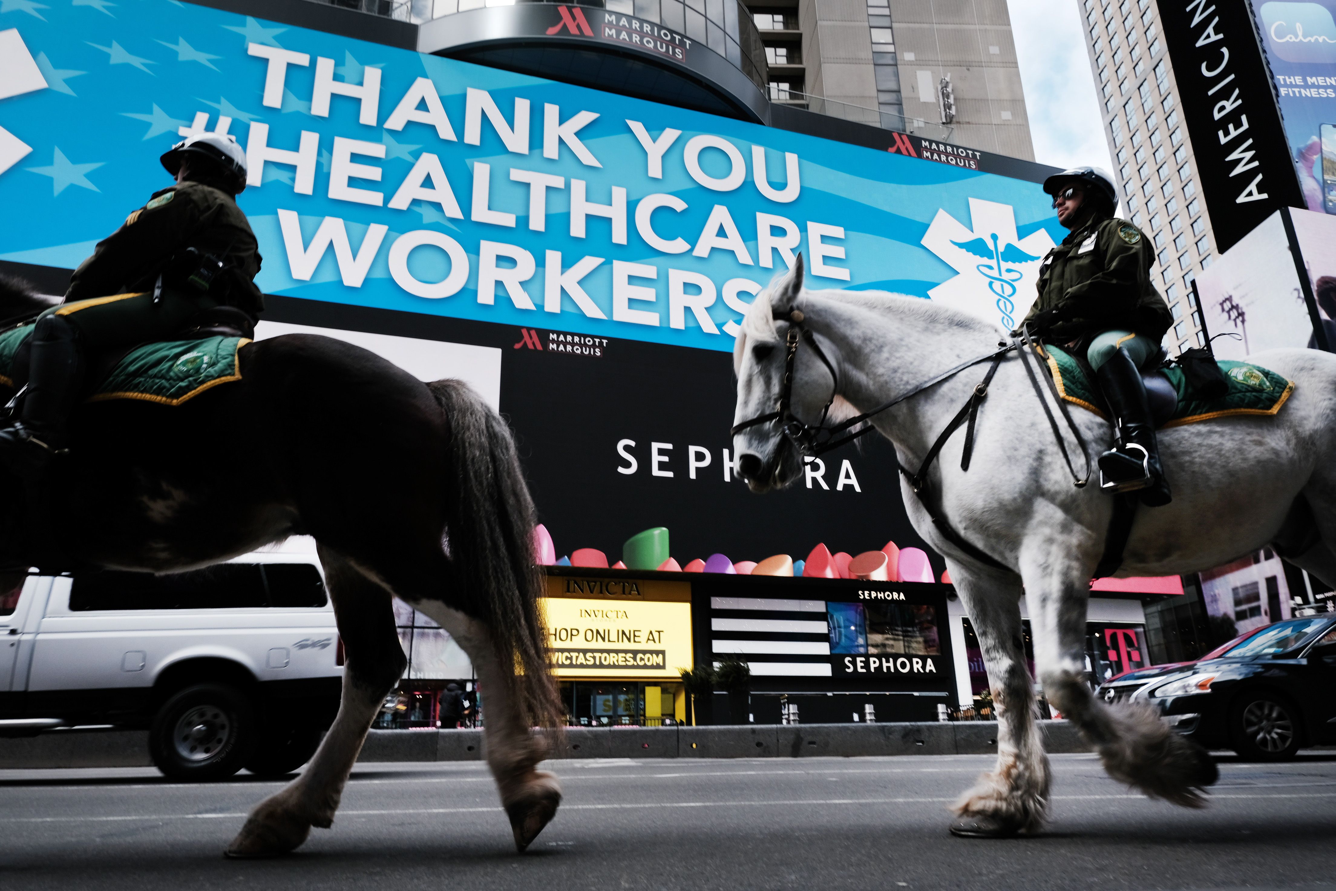 Police ride horses through Times Square as it stands mostly empty as much of the city is void of cars 