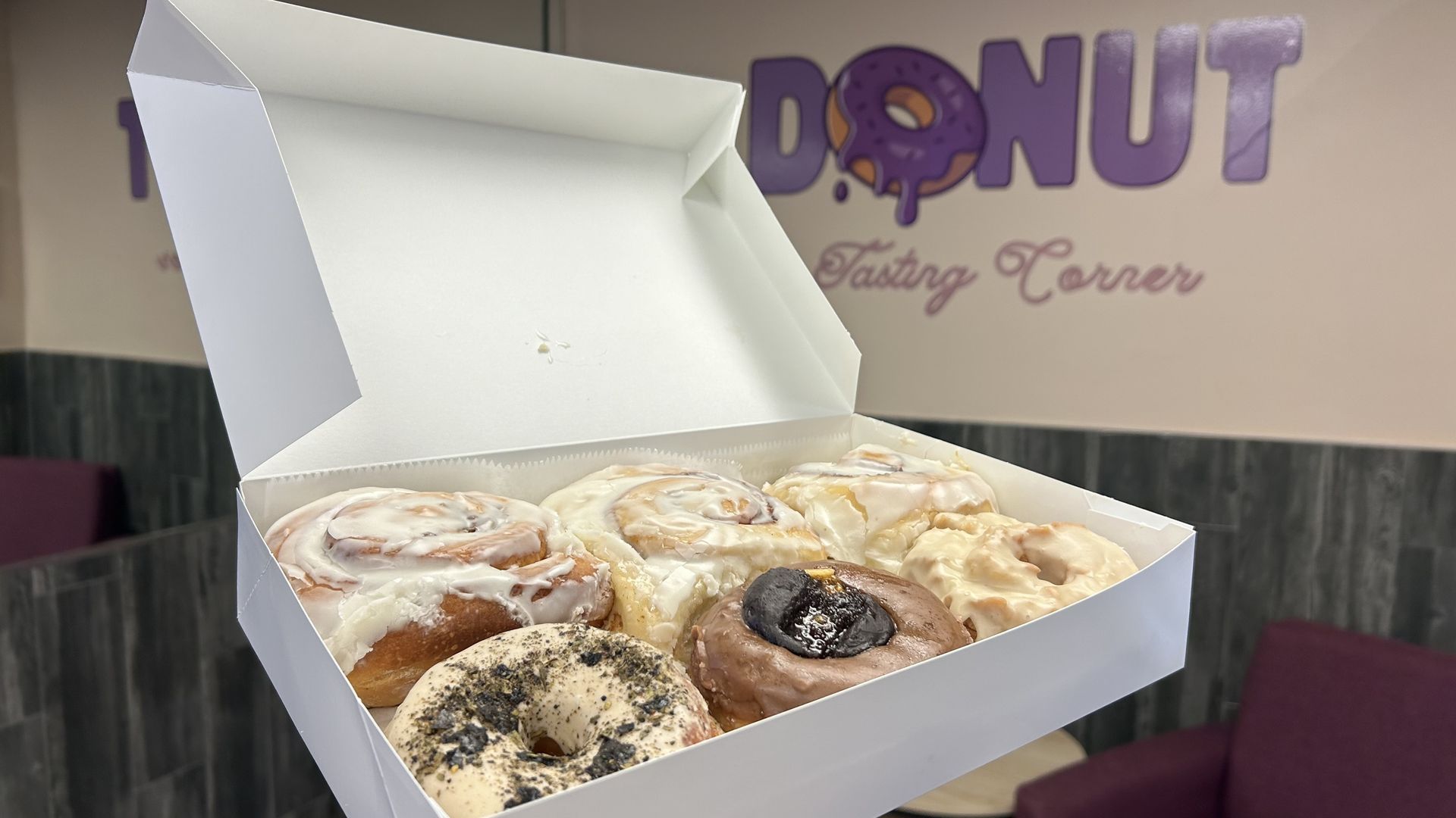 hand holding a half dozen box of doughnuts