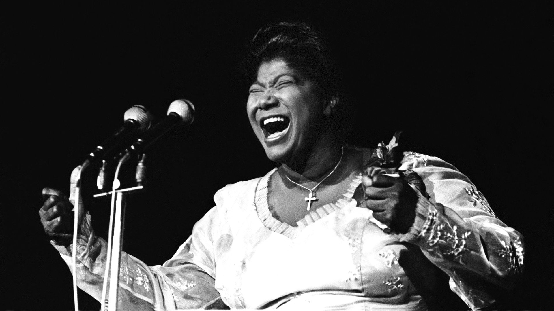 Photo shows Mahalia Jackson singing on stage in a black and white photo