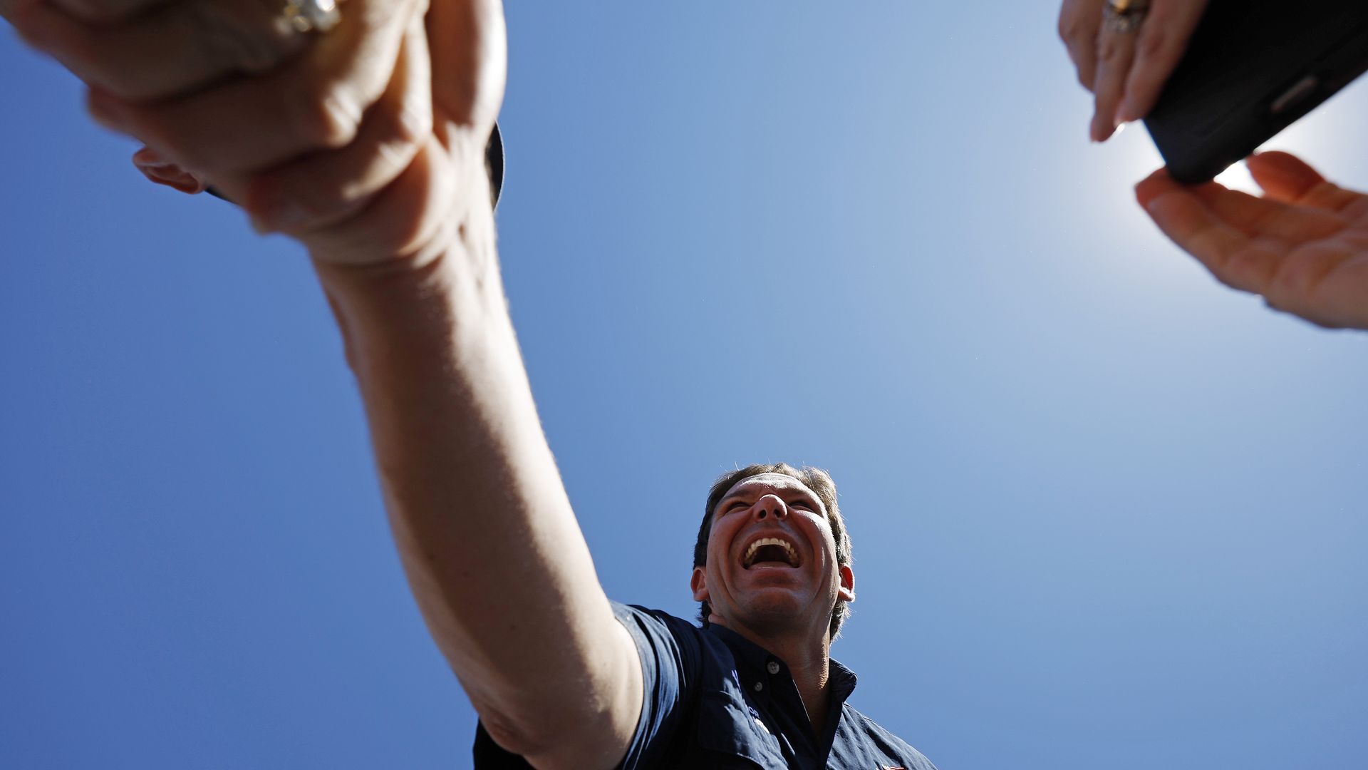 Florida Gov. Ron DeSantis shakes someone's hand while campaigning in Iowa.