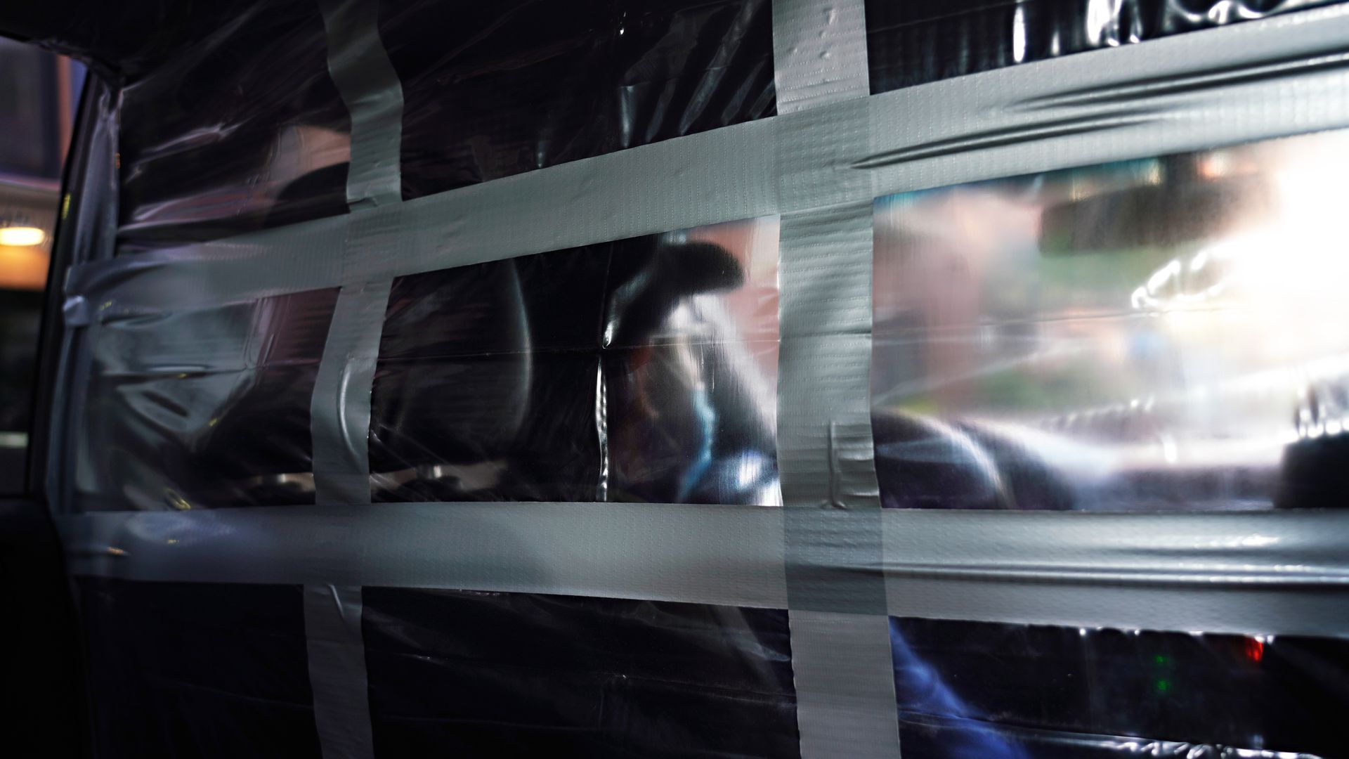 The silhouette of a man seen through clear plastic and duct tape sheeting