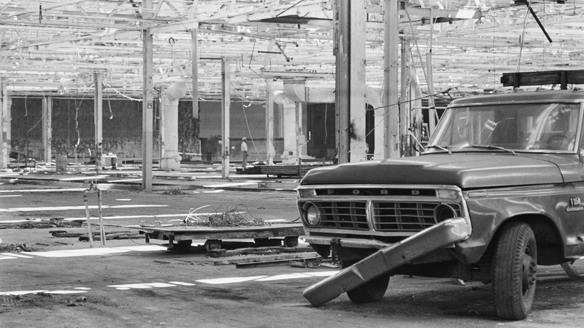 Black and white photo of a broken-down Ford truck in an abandoned factory