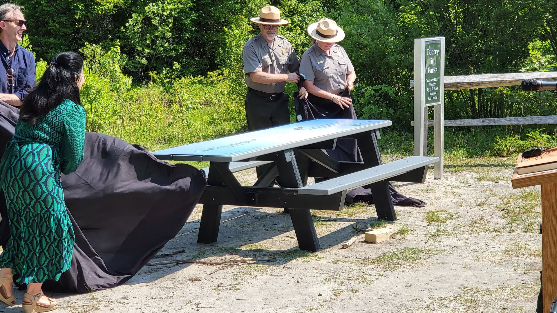 a woman pulls a cover off a picnic table