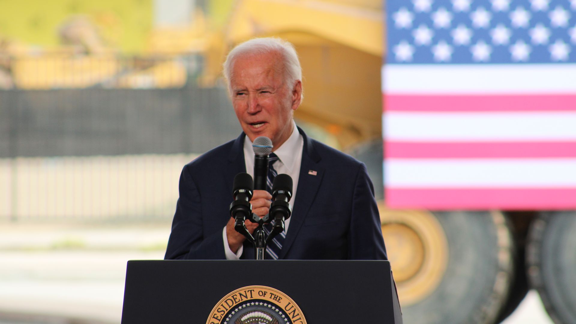 President Biden stands at a lectern speaking into a microphone