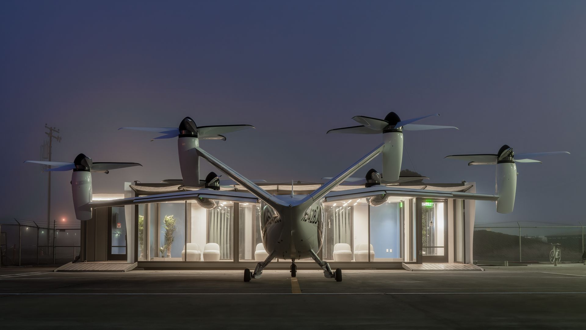 Nightime image of a electric air taxi parked in front of a so-called vertiport where commuters can catch a convenient flight to or from the airport. 
