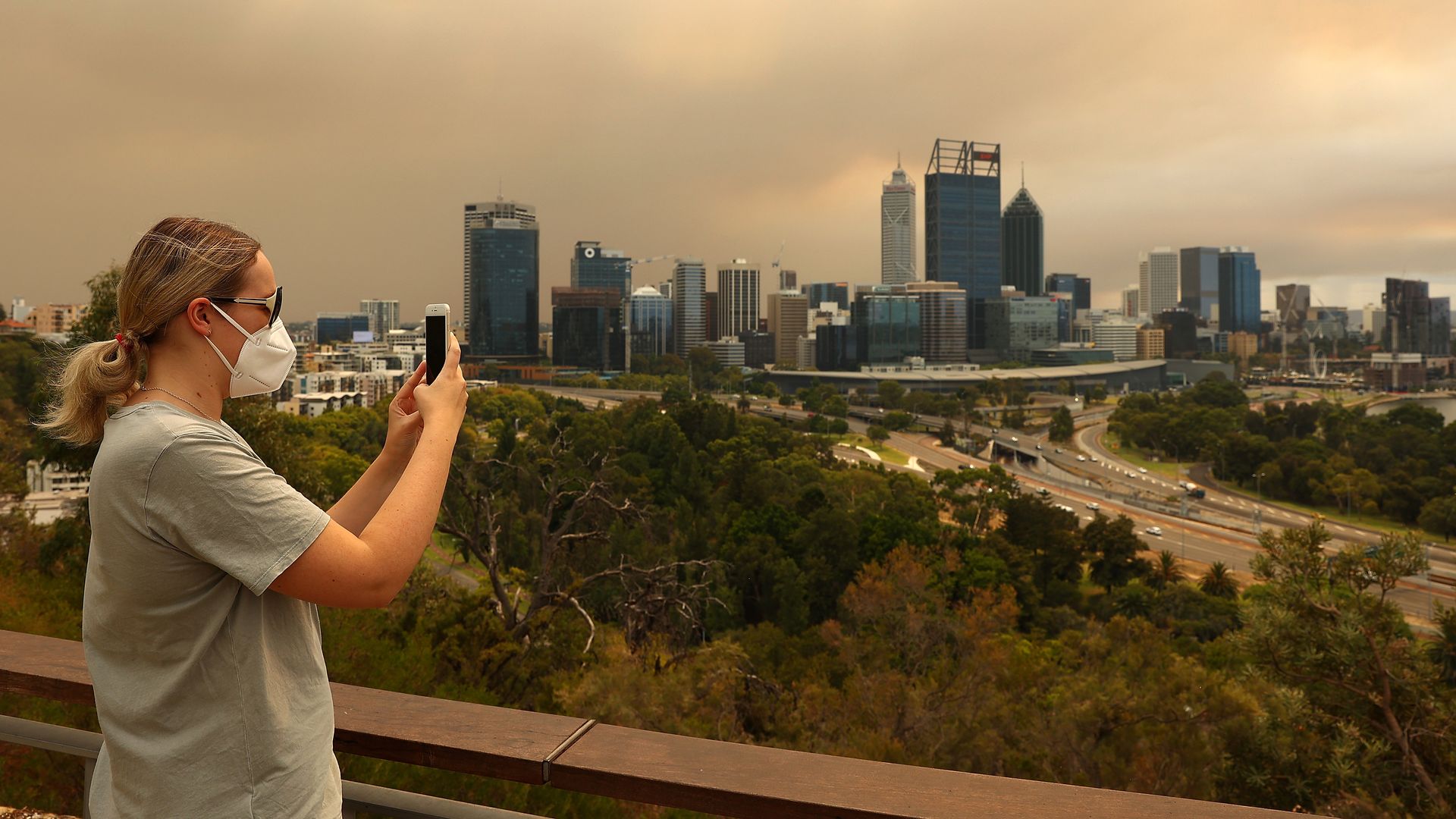  A local resident takes a panoramic image of the bush fire and Perth CBD on her phone from Kings Park on February 02, 2021 in Perth, Australia. 