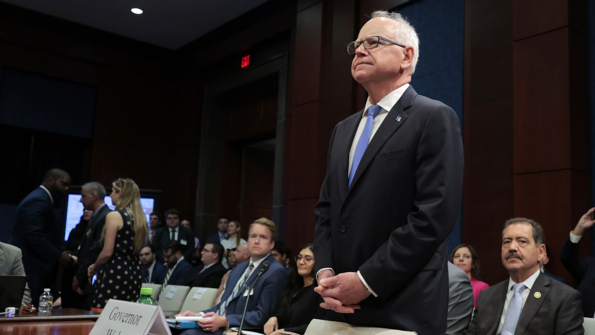 Walz stands at a table in a capitol hill hearing room 