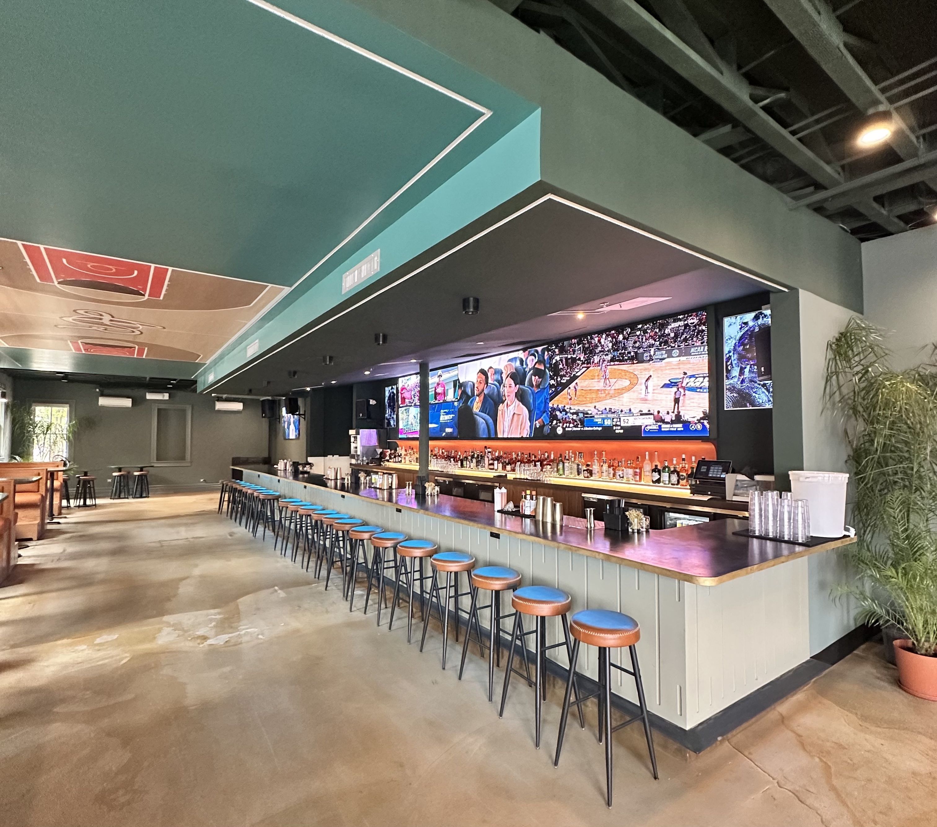 An empty bar featuring a large TV and bright accents.
