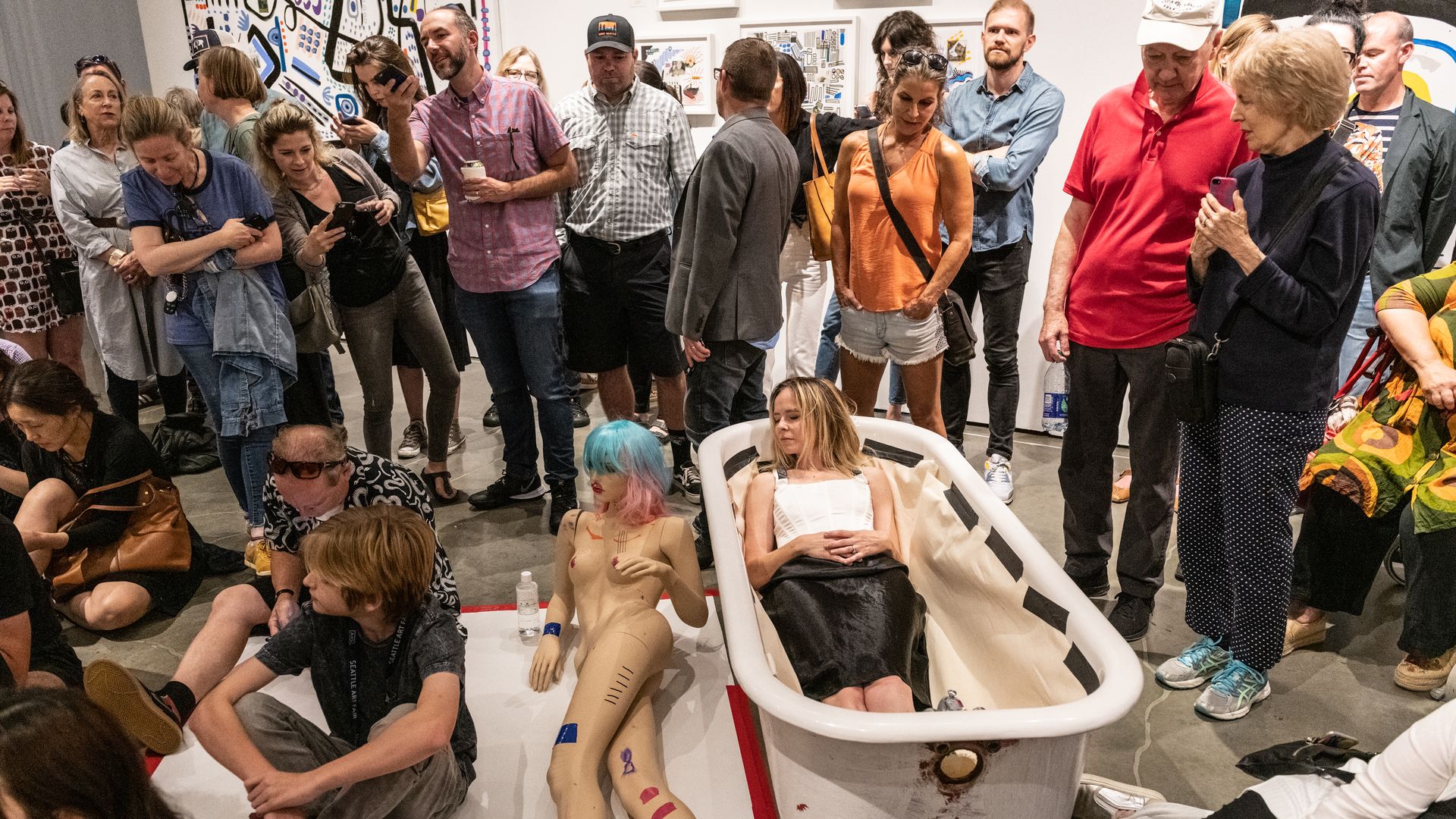 An artist lies in a bathtub as part of a performance art exhibit during the Seattle Art Fair. 