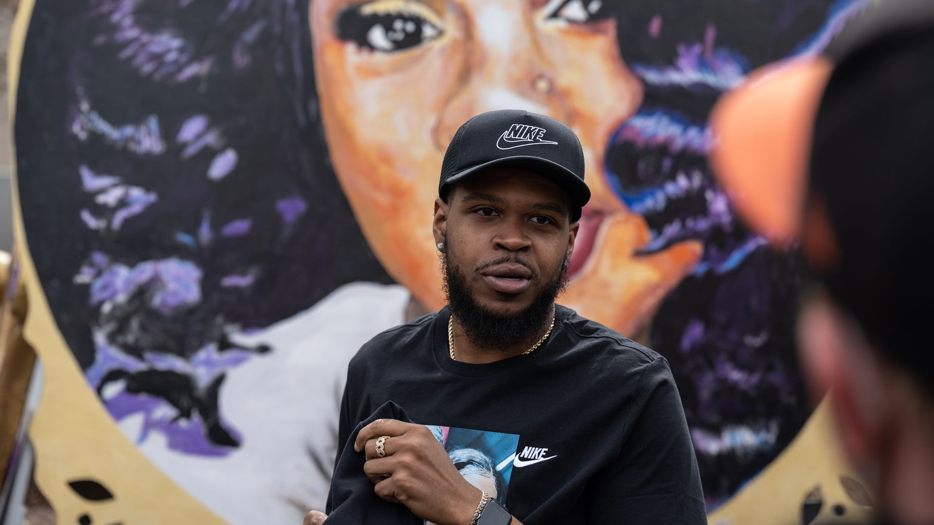 Kenneth Walker, boyfriend of Breonna Taylor, stands in front of a portrait of Taylor during a protest memorial for her in Jefferson Square Park on March 13, 2021 in Louisville, Kentucky.