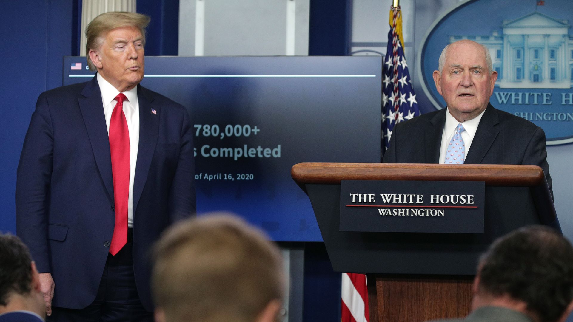 Trump and Sonny Perdue stand next to each other in this image