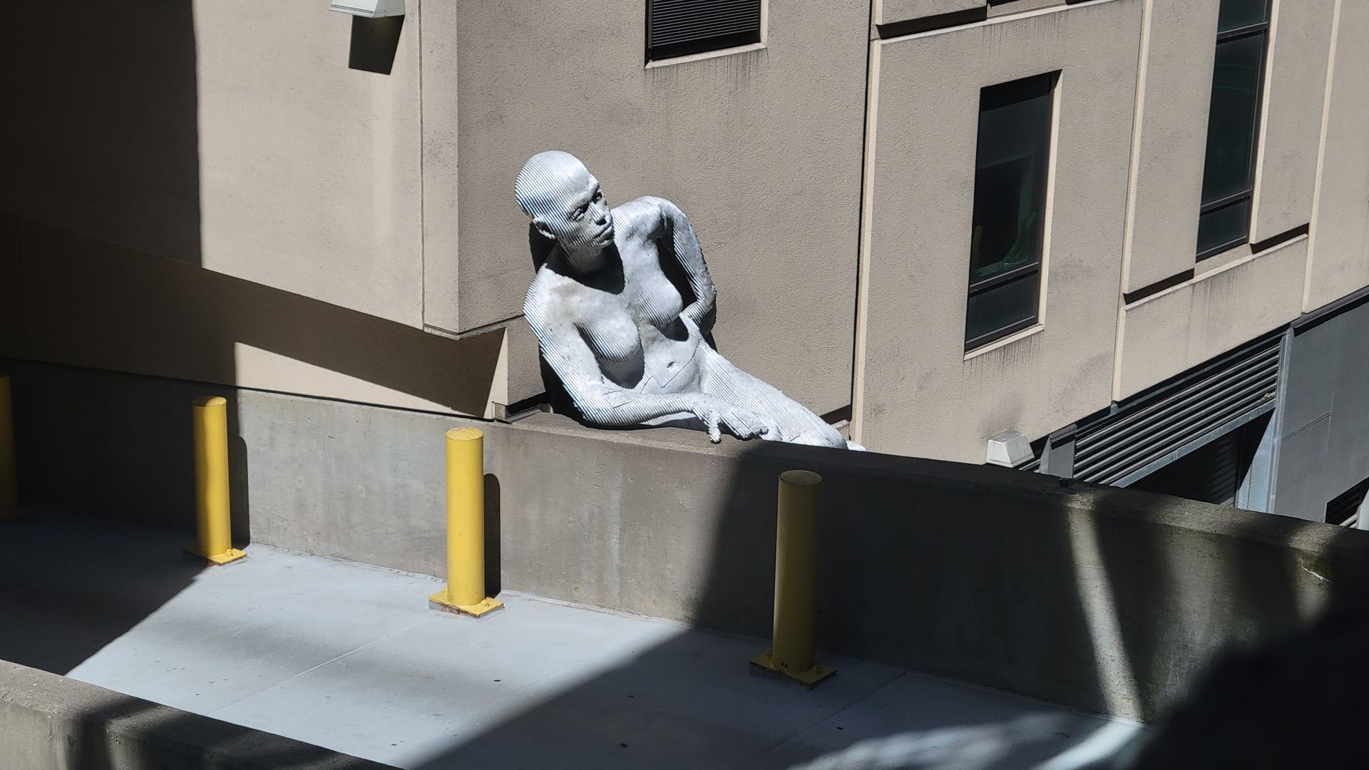 A statue of of a person near a pedestrian footbridge in Philadelphia. 